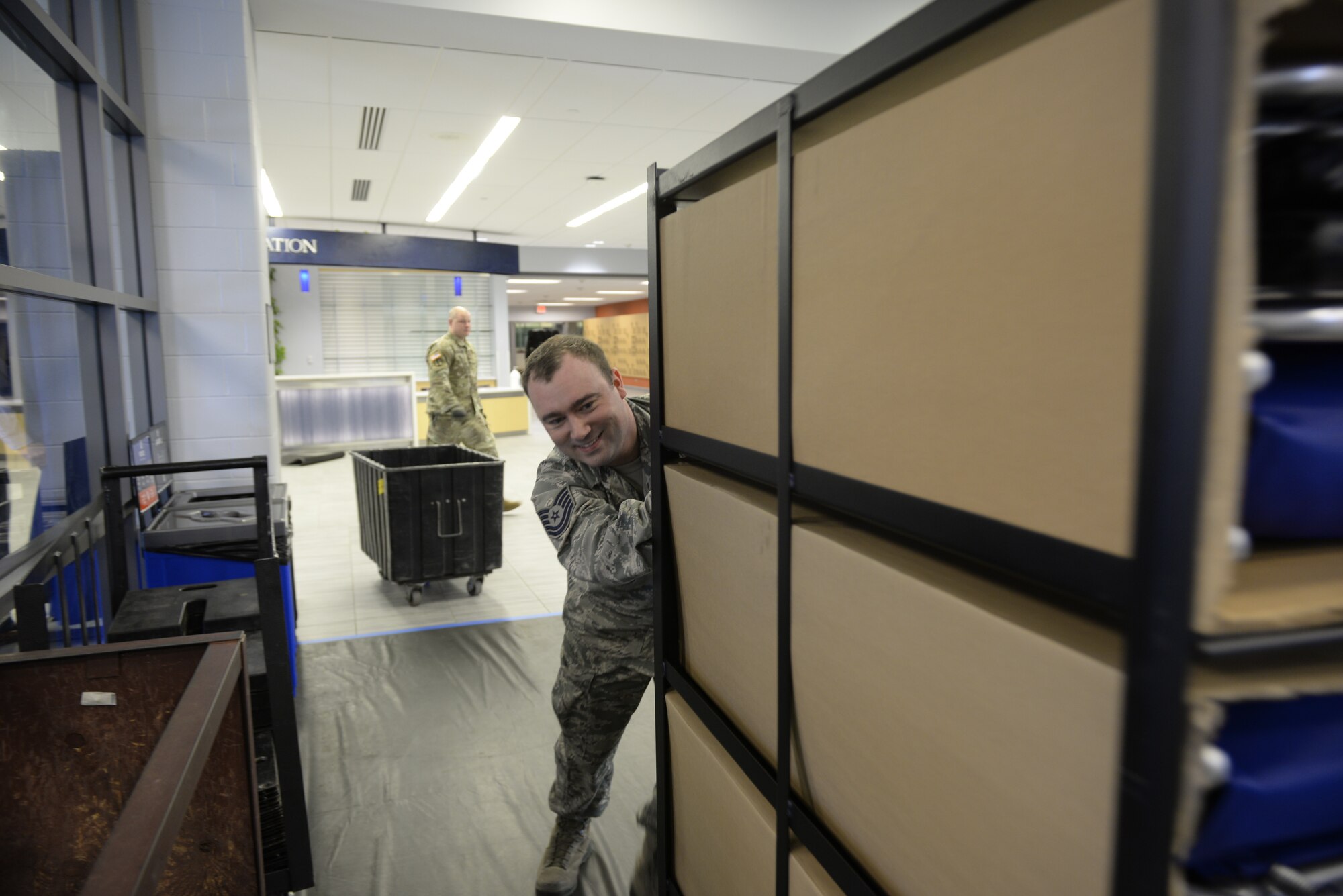 Tech. Sgt. Lance Whitehill, 157th Civil Engineers Squadron, New Hampshire Air National Guard, brings supplies into the Hamel Recreation Center at the University of New Hampshire, March 25, 2020. The facility will augment area hospitals treating COVID-19 cases, if necessary. It is one of nine the NHNG plans to set up and manage across the state. (U.S. Air National Guard photo by Tech. Sgt. Aaron Vezeau)