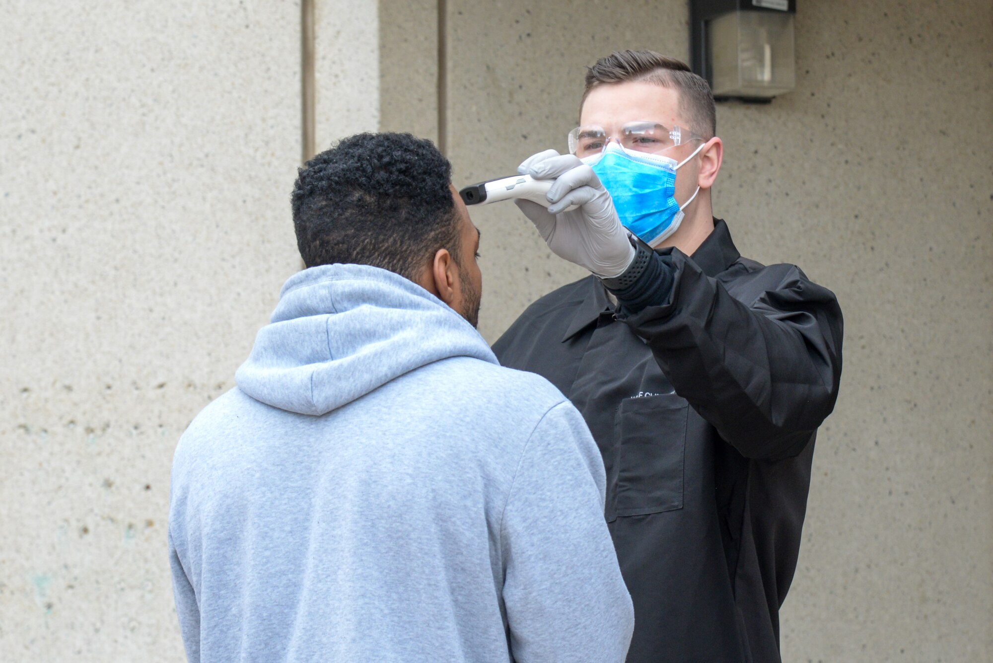 Airman 1st Class Kyle Larson, a medical technicial with 75th Medical Group, screens an incoming patient before entering the Hill Air Force Base, Utah medical clinic March 31, 2020.