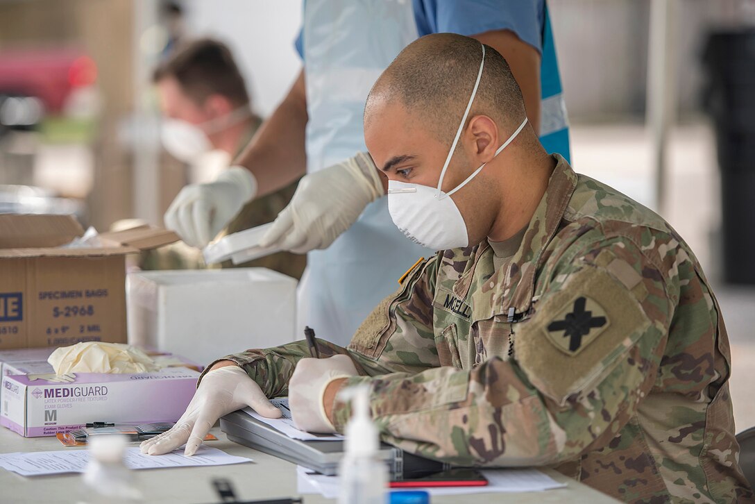 Masked soldier processes swabs.