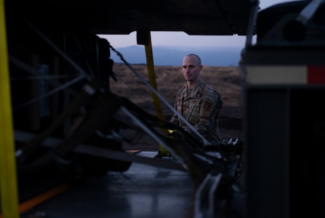 Airman 1st Class Timothy Skelton, 374th Logistics Readiness Squadron vehicle operator, anchors bundles onto a trailer