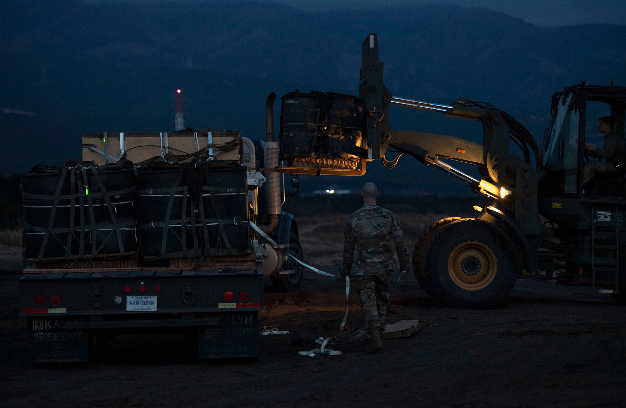 Airman 1st Class Timothy Skelton, 374th Logistics Readiness Squadron vehicle operator, watches as a bundle is loaded onto a trailer