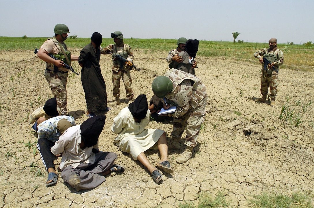 Iraqi soldiers from 3rd Brigade, 5th Iraqi army, question apprehended insurgents at detainee collection point during Operation Peninsula, in Wasit Provence, Iraq, May 20, 2005 (U.S. Army/Arthur Hamilton)