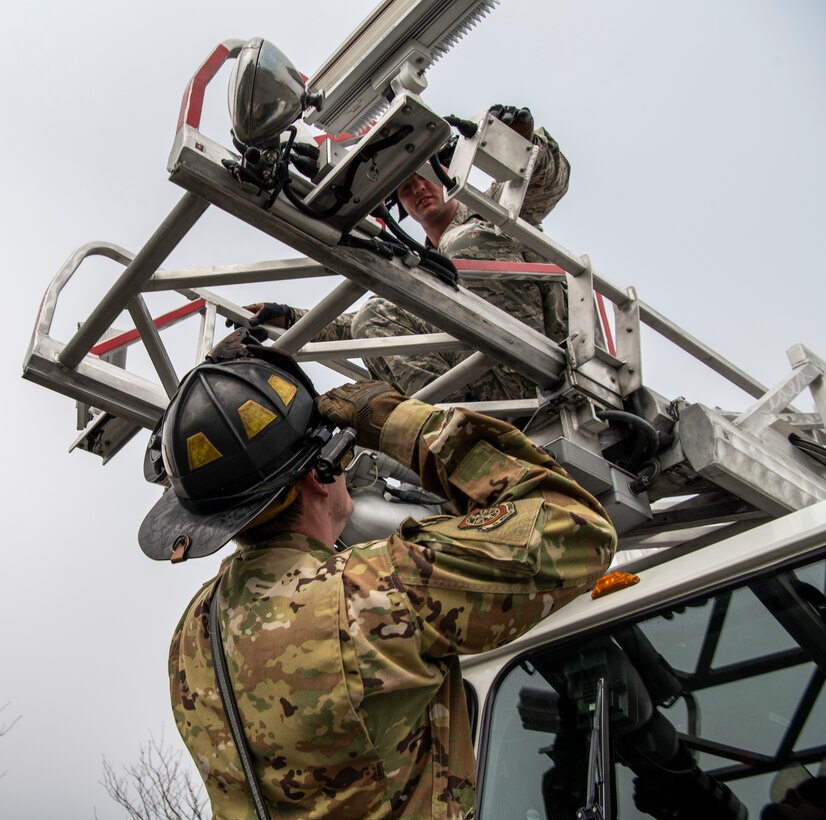 Staff. Sgt. Justin Tarr (left), 436th Civil Engineer Squadron crew chief, and Senior Airman James Lock, 436th Civil Engineer Squadron driver, check to see if the fire truck’s ladder is seated correctly at Dover Air Force Base, Delaware, March 30, 2020. Despite the COVID-19 pandemic and signifcantly reduced manning, Dover AFB fire remains ready for emergencies and to support response efforts. (U.S. Air Force photo by Senior Airman Christopher Quail)