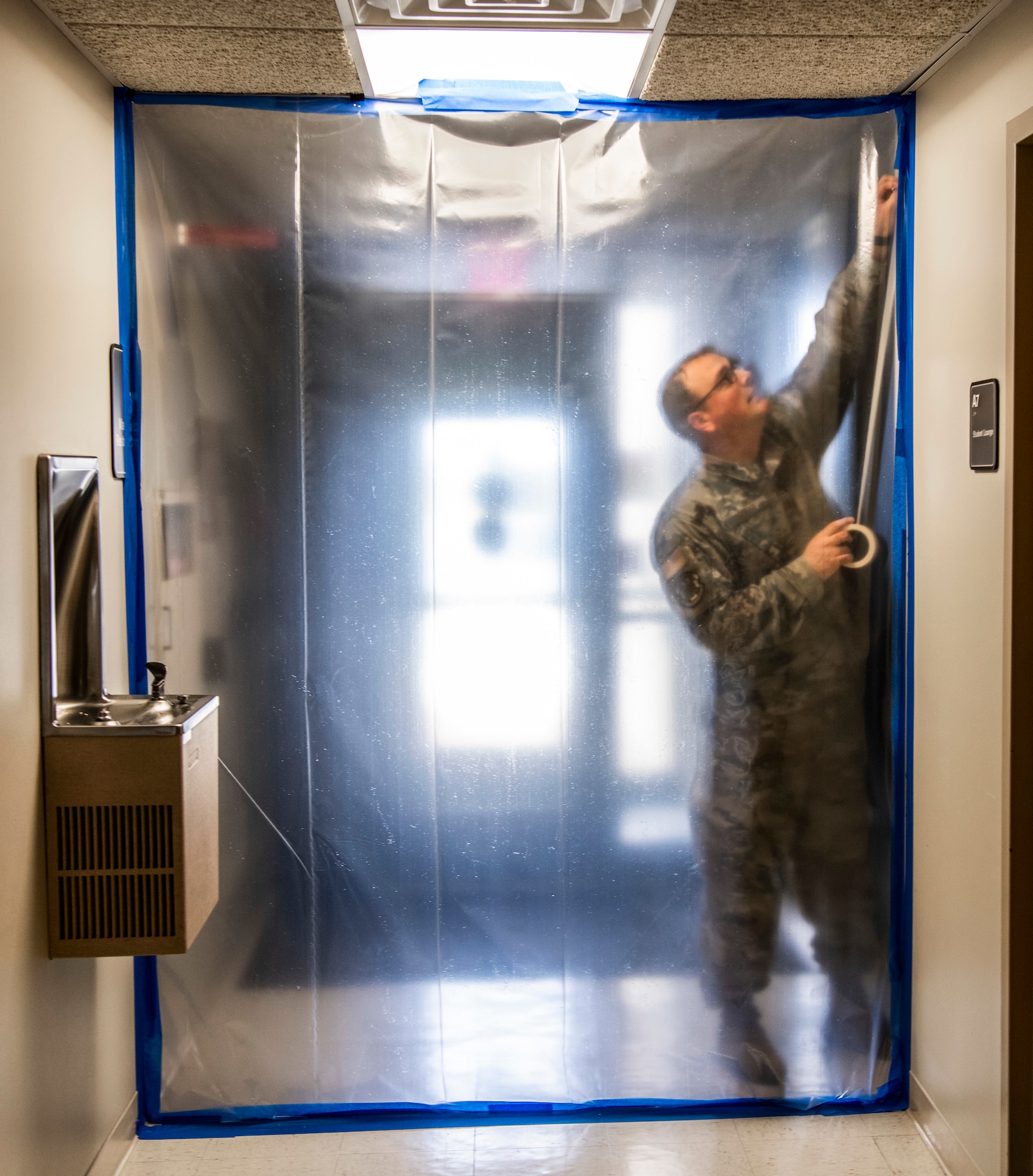 Master Sgt. Jonathan Platt, 436th Operational Medical Readiness Squadron dental flight chief, tapes up the hallway at Dover Air Force Base, Delaware, March 30, 2020. Platt helped tape hallway entrances to section off areas within the dental clinic to be used for potential COVID-19 patients. Dover AFB medical personnel continue to care for Airmen and their families, while supporting state and national response efforts. (U.S. Air Force photo by Senior Airman Christopher Quail)
