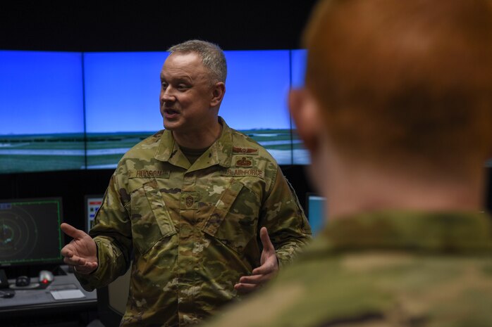 U.S. Air Force Chief Master Sgt. Philip Hudson, 7th Air Force command chief, speaks with Tech. Sgt. Patrick Hart, 8th Operations Support Squadron NCO in charge, during a base visit at Kunsan Air Base, Republic of Korea, March 26, 2020. Hudson learned about how the 8th Fighter Wing is ensuring the safety of Airmen on base and how they modified unit operations to accomplish their mission and remain safe during the COVID-19 response. (U.S. Air Force photo by Senior Airman Jessica Blair)