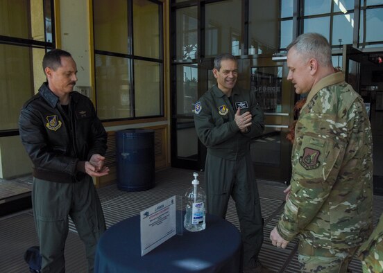 U.S. Air Force Lt. Gen. Kenneth Wilsbach, 7th Air Force commander, and Chief Master Sgt. Philip Hudson, 7th Air Force command chief, sanitize their hands at the front entrance of the fitness center during their visit at Kunsan Air Base, Republic of Korea, March 27, 2020. During the visit, Wilsbach had the opportunity to speak with Airmen from different entities around base to see what precautionary measures they are taking to keep the base safe and healthy. (U.S. Air Force photo by Senior Airman Jessica Blair)