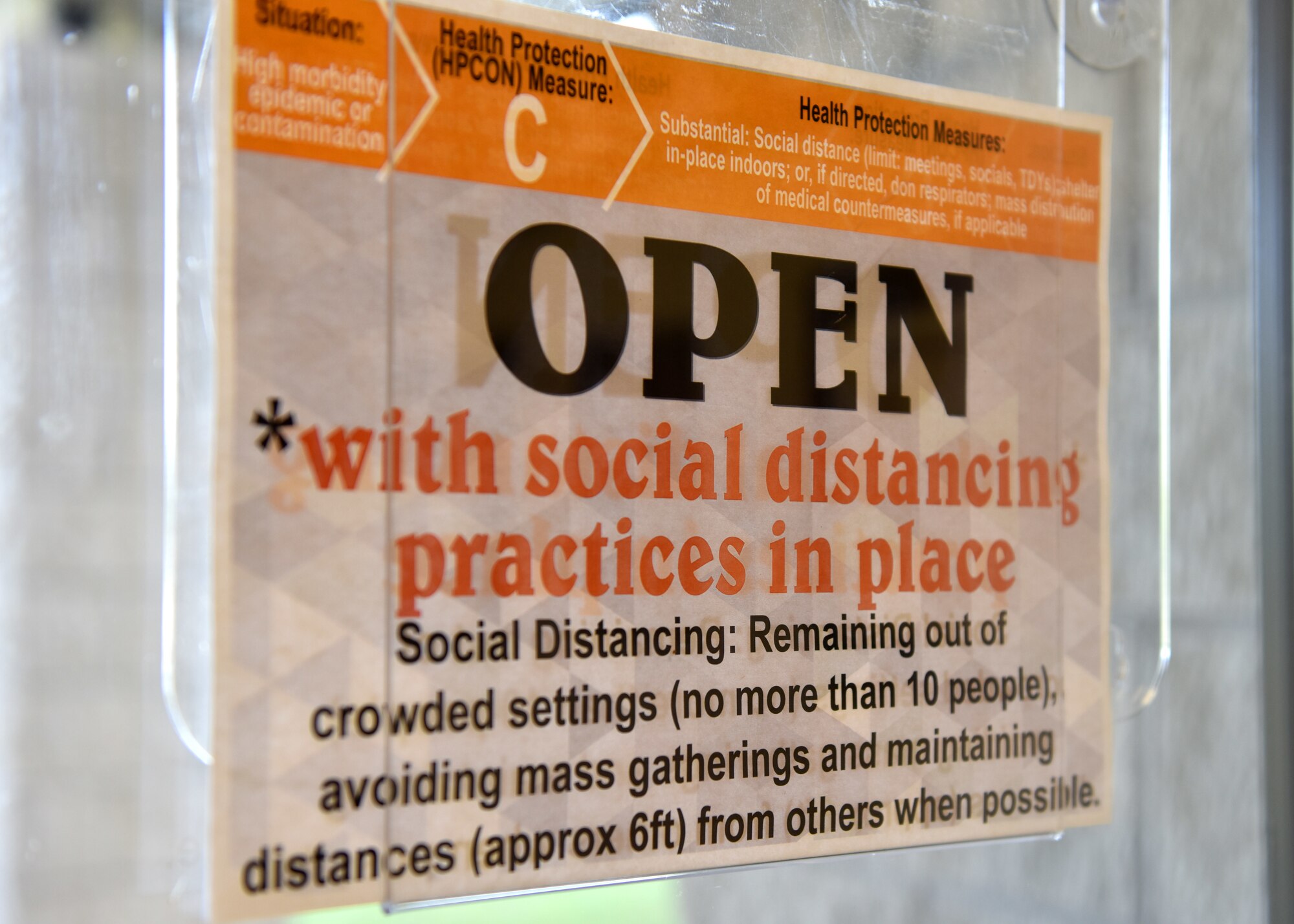 A sign on the door of the school-age program building informs individuals of the precautions in place while the building is open at Goodfellow Air Force Base, Texas, March 30, 2020. Signs are displayed on any organization that is remaining open during the COVID-19 outbreak. (U.S. Air Force photo by Senior Airman Seraiah Wolf)