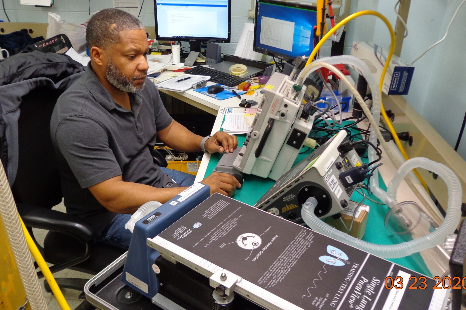 Man works on ventilator.