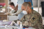 Masked soldier processes swabs.