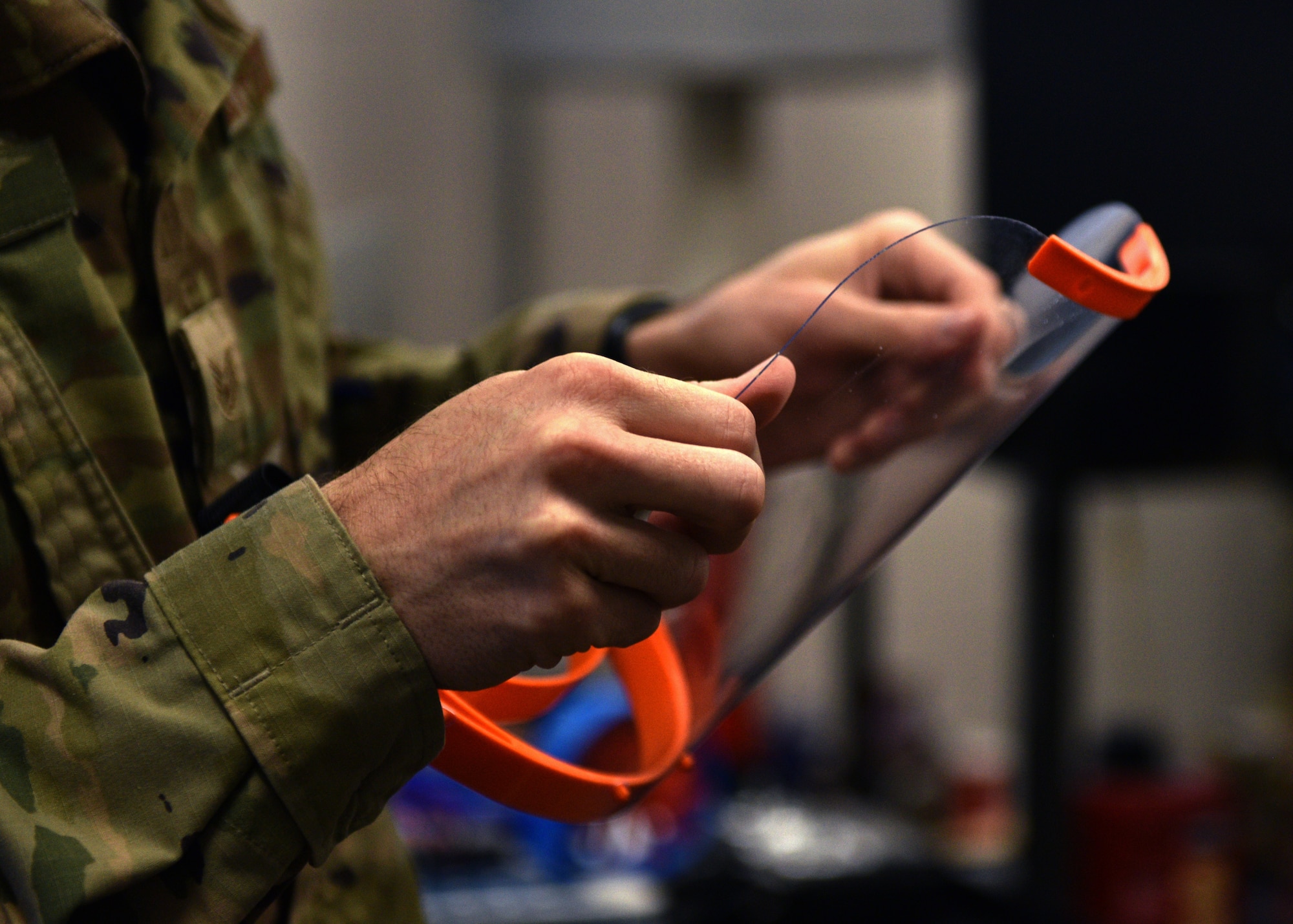 U.S. Air Force Staff Sgt. Jonathan Bahr, 312th Training Squadron Special Instruments Training course instructor, prepares a 3D printed face shield at the Louis F Garland Department of Defense Fire Academy on Goodfellow Air Force Base, Texas, March 31, 2020. The SPINSTRA instructor team is 3D printing a series of medical supply prototypes in hopes of providing the local medical facilities with more face masks and shields. (U.S. Air Force photo by Airman 1st Class Robyn Hunsinger)