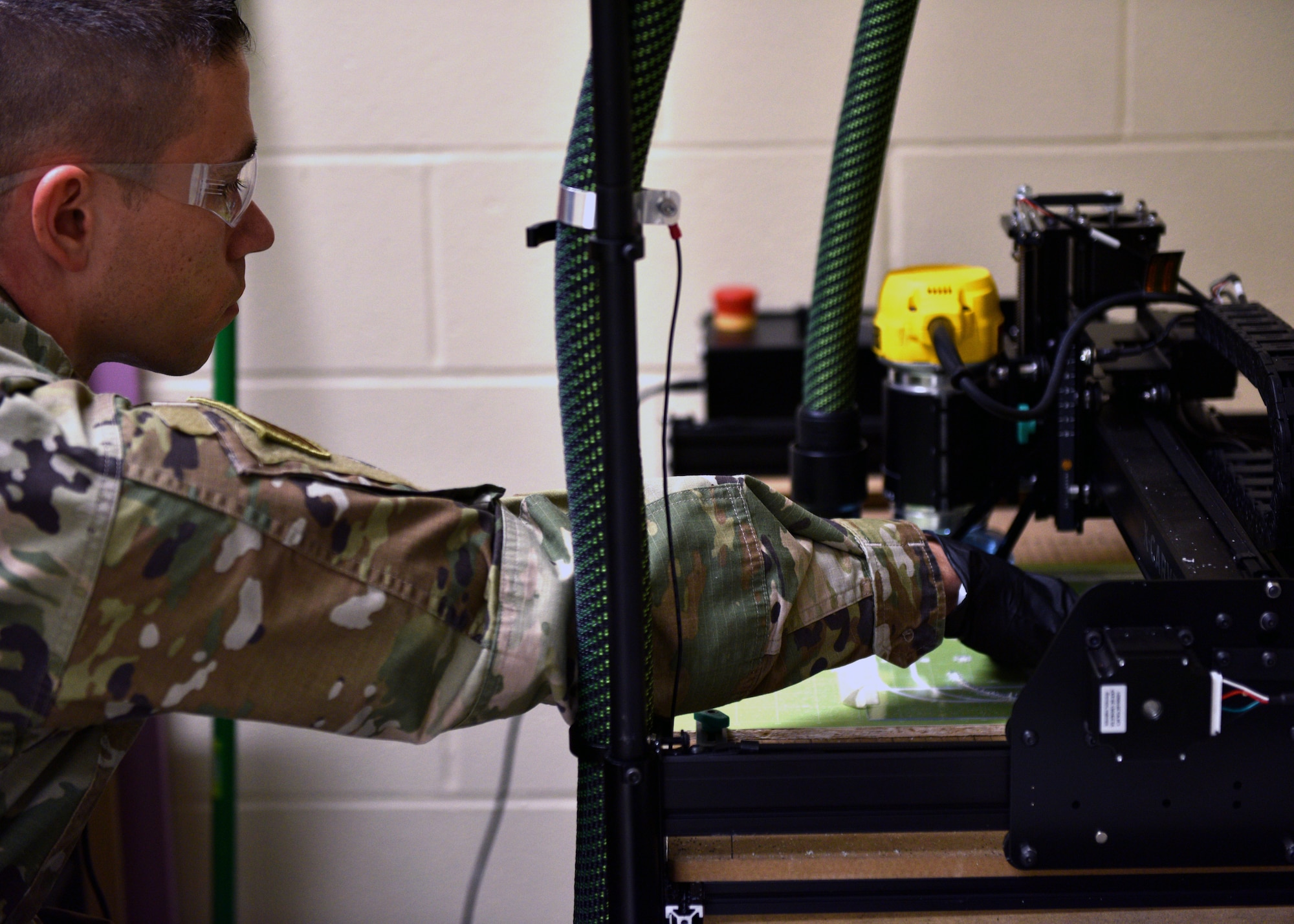 U.S. Air Force Tech. Sgt. Donald Kramer, 312th Training Squadron Special Instruments Training course instructor supervisor, cuts the clear, plastic shield for the 3D printed face shields at the Louis F Garland Department of Defense Fire Academy on Goodfellow Air Force Base, Texas, March 31, 2020. Many SPINSTRA instructors have personal 3-D printers home, providing more resources to the project. (U.S. Air Force photo by Airman 1st Class Robyn Hunsinger)