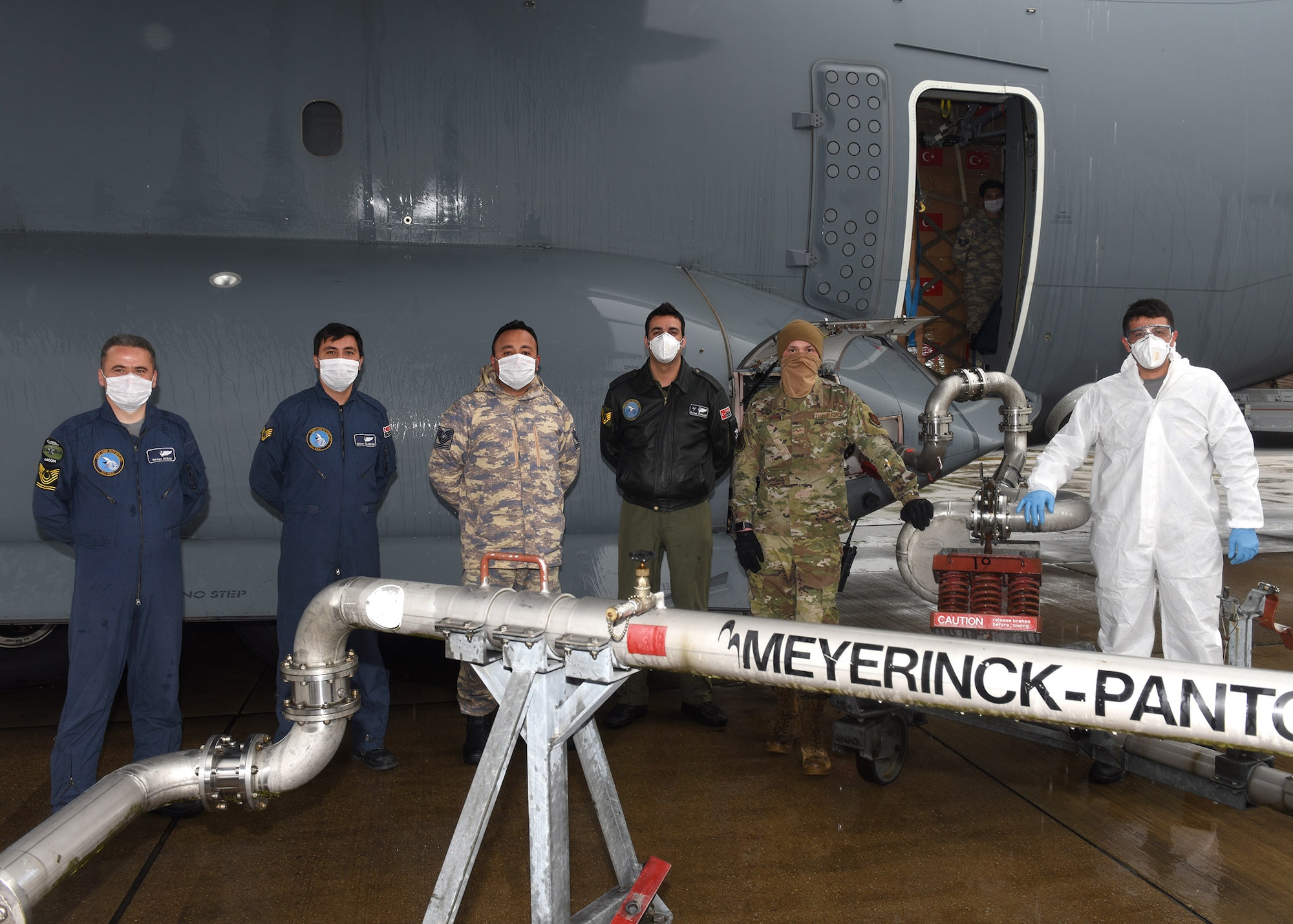 Turkish air force aircrew and Team Mildenhall Airmen pose for a photo during ground refueling of a Turkish Airbus A400M Atlas at RAF Mildenhall, England, April 28, 2020. The aircraft and crew were transporting COVID-19 medical supplies to Joint Base Andrews, Md., including goggles, gloves, masks and protective clothing. Airmen from RAF Mildenhall were ready and waiting to assist the crew and refuel the aircraft, demonstrating our mutual support of NATO allies during this difficult time. (U.S. Air Force photo by Karen Abeyasekere)