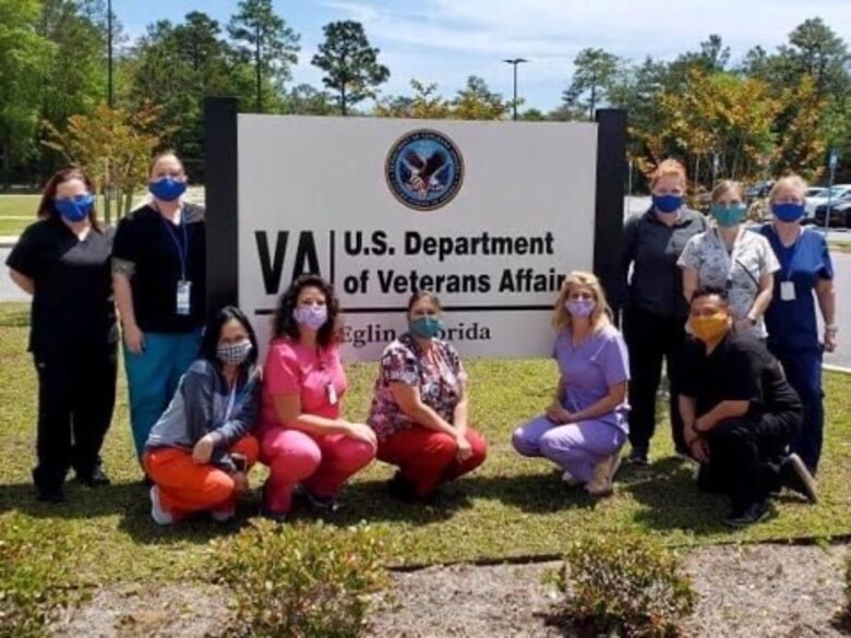 A group of medical personnel pose in front of the U.S. Department of Veteran Affairs sign, Eglin Air Force Base, Fla.