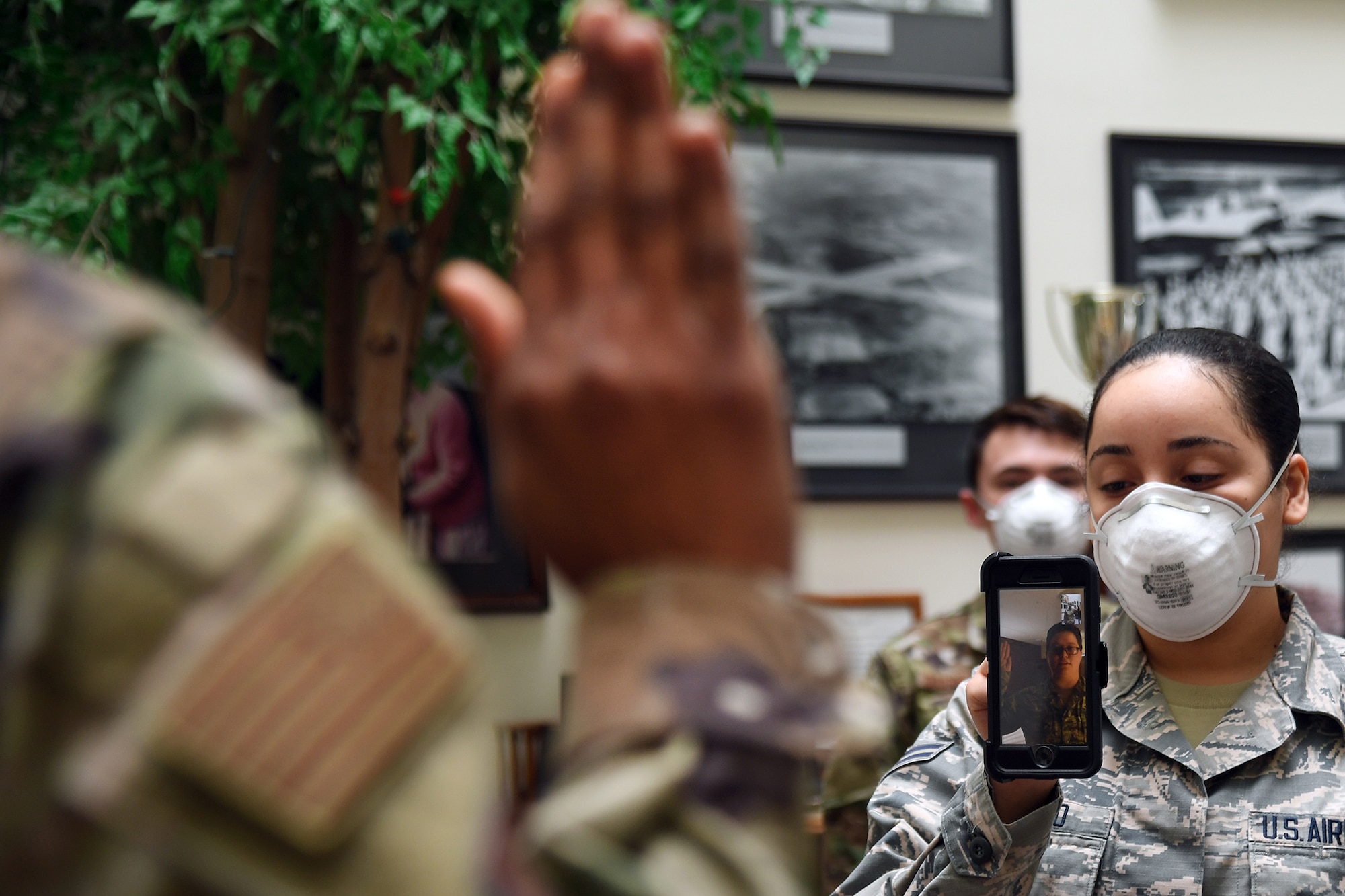 Maj. Yaira Nevarez, left, 66th Force Support Squadron deputy director, administers the oath of enlistment to Staff Sgt. Jennifer Rogers during a virtual reenlistment at Hanscom Air Force Base, Mass., April 28, while Airman 1st Class Jazlynn Liranzo, 66 FSS Career Development technician, holds the phone and Senior Airman Dominik Daigneault, 66 FSS Force Management journeyman, looks on. Rogers, whose background is as a cryptologic language analyst, is returning to active duty following participation in the Career Intermission Program. (U.S. Air Force photo by Linda LaBonte Britt)