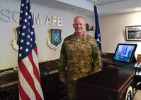 Maj. Gen. Michael Schmidt, program executive officer for Command, Control, Communications, Intelligence, and Networks, stands next to a video teleconference monitor during a virtual promotion ceremony held at Hanscom Air Force Base, Mass., for three enlisted Airmen from Joint Base San Antonio-Lackland, Texas, April 30. (U.S. Air Force photo by Linda LaBonte Britt)