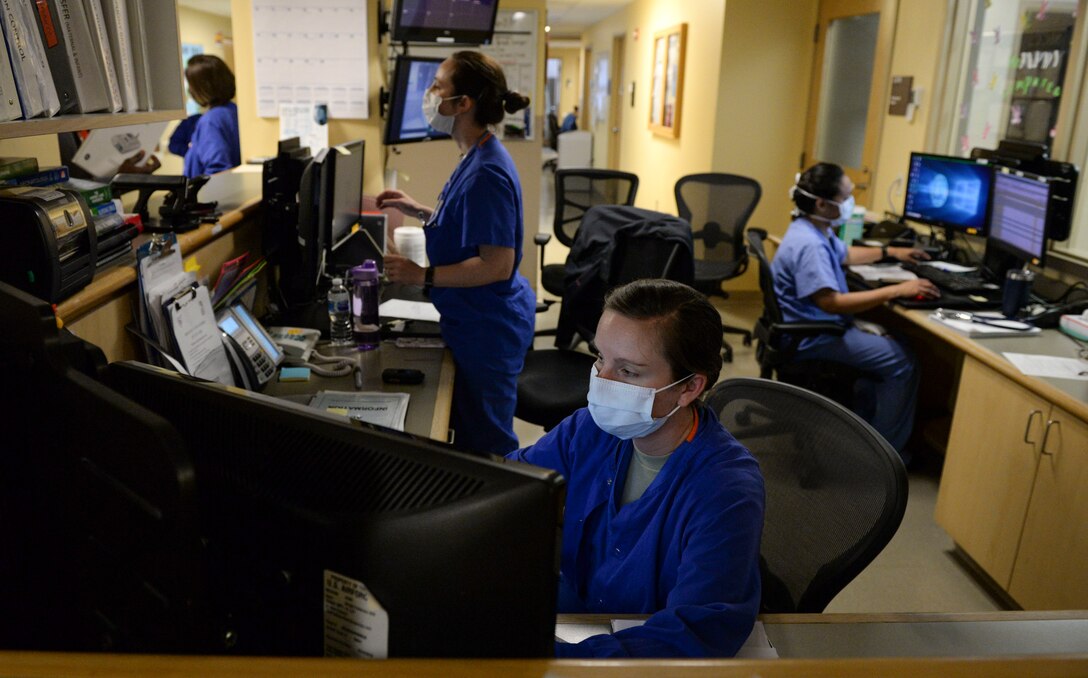 Nurses with the 88th Medical Group chart patient data and monitor patients from a nurses station inside the medical center at Wright-Patterson Air Force Base, Ohio, April 28, 2020. The 88th Medical Group is one of the largest Air Force Military Treatment Facilities providing primary and specialty care to over 58,000 eligible beneficiaries. (U.S. Air Force photo by Wesley Farnsworth)