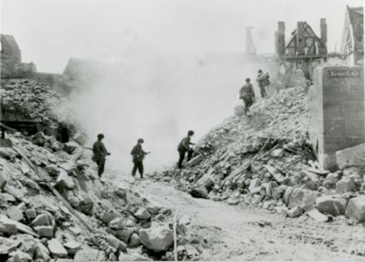Soldiers wander through the rubble of a destroyed town.