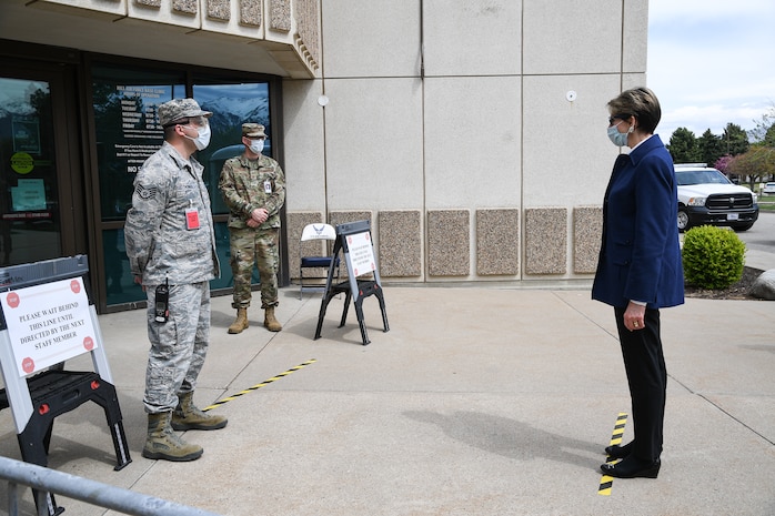 Secretary of the Air Force Barbara Barrett is screened by Staff Sgt. Ryan Thomas, 75th Medical Group, near the front doors of the medical clinic.
