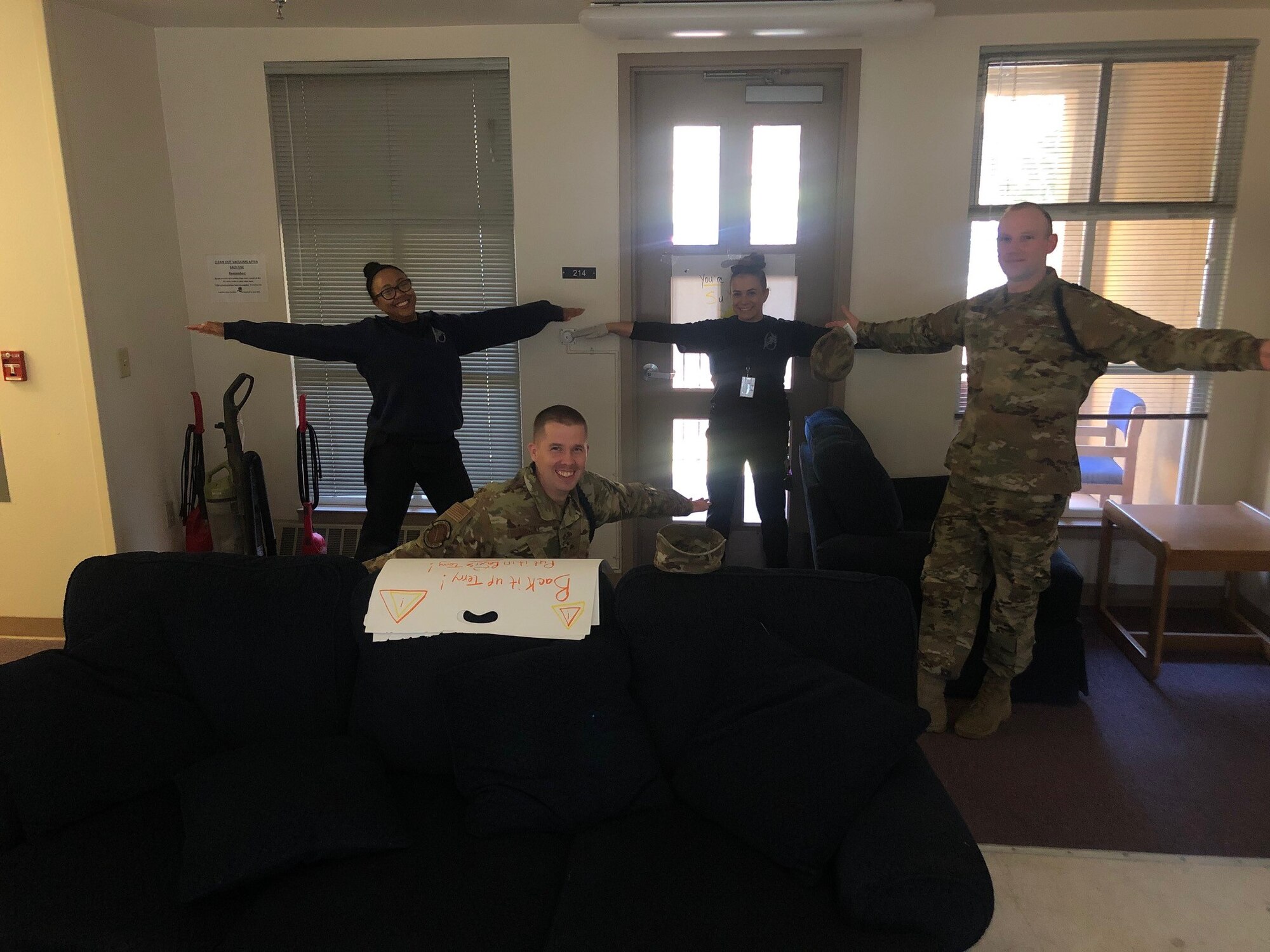 Military Training leaders with the 314th Training Squadron practice social distancing while hanging posters for Airmen morale. Due to COVID-19, the MTLs must maintain a distance of six feet apart, but they remain there to help the Airmen through boosting morale and virtual meetings. (Courtesy Photo)