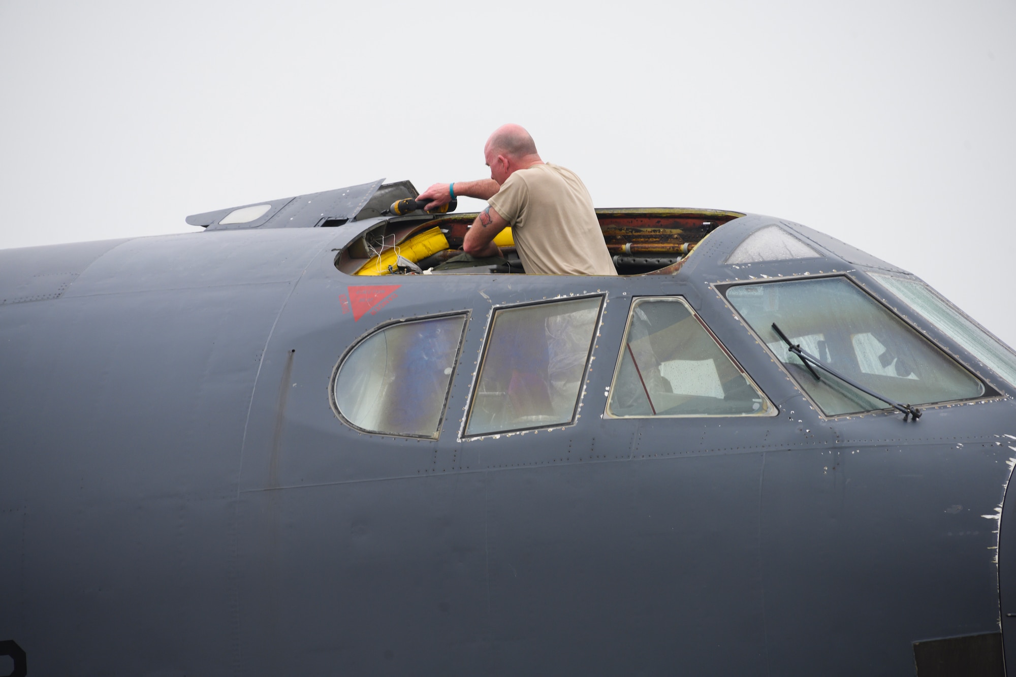 Photo of airman working on hatch of B-52