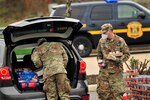 Spc. Vassindou Kamagate, left, and Sgt. 1st Class Brian Turner, horizontal construction engineers with the Delaware Army National Guard's 160th Engineer Company, distribute canned goods at a drive-thru mobile pantry in Newark, Delaware, April 20, 2020.