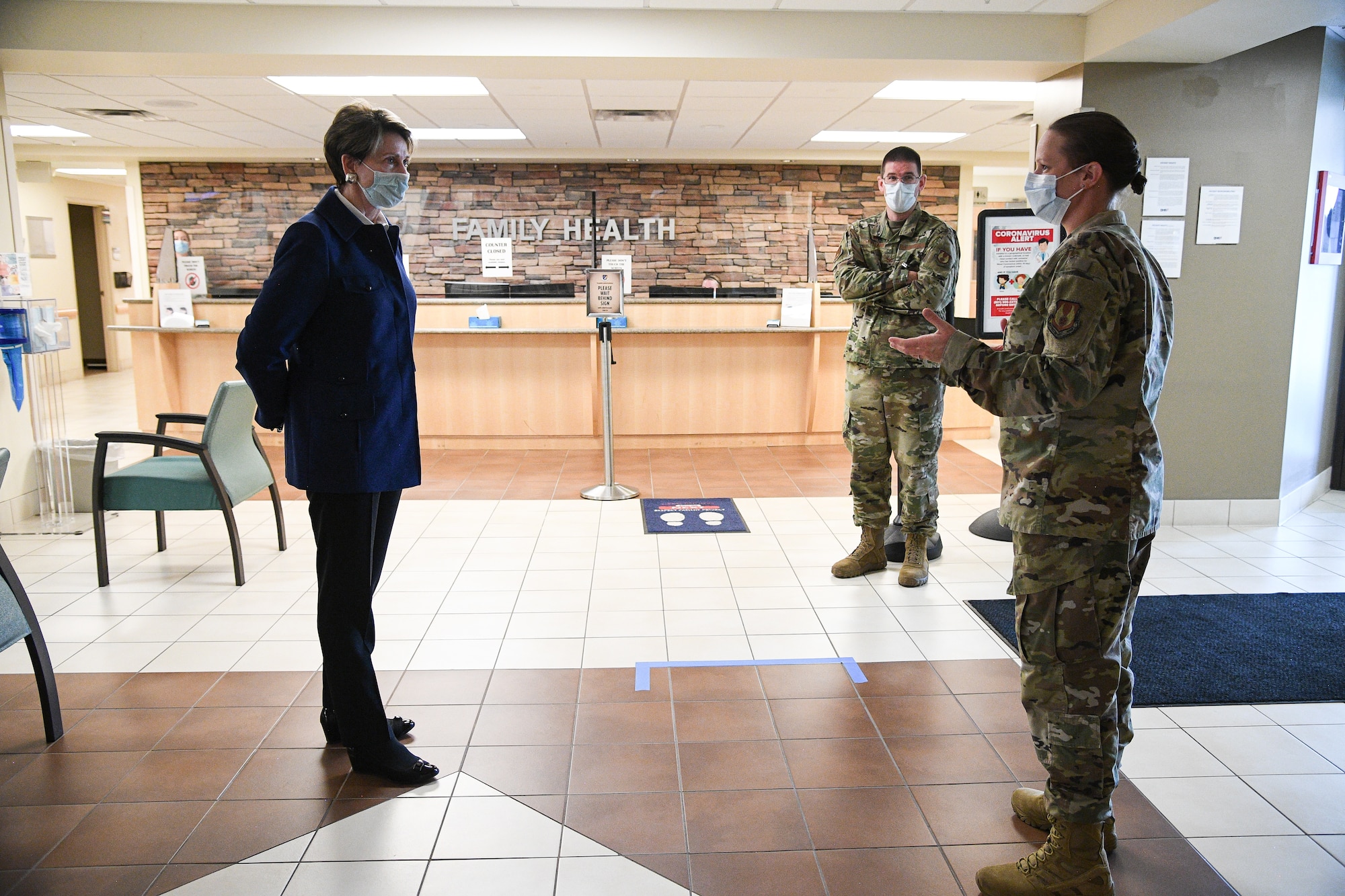 Secretary of the Air Force Barbara Barrett listens to Lt. Col. Jennifer Hardos, 75th Medical Group, in the lobby of the medical clinic.