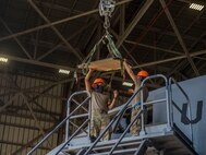 Staff Sgt. Eugino Rivas, left, and Senior Airman Sean McGrath, right, both crew chiefs assigned to the 437th Aircraft Maintenance Squadron, install a new window in the flightdeck of a C-17 Globemaster III aircraft at Joint Base Charleston, S.C., April 28, 2020. The 437th AMXS is still generating aircraft to support local training flights, missions from Air Mobility Command and supporting training for aeromedical evacuation personnel while being critically manned during the COVID-19 pandemic. The 437th AMXS is also implementing physical distancing when possible and following other Centers for Disease Control guidelines. Additionally, they have trained some of their personnel to decontaminate aircraft before and after missions to keep aircrews and 437th AMXS personnel safe. (U.S. Air Force Photo by Staff Sgt. Megan Munoz)