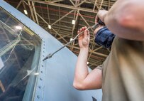 Senior Airman Sean McGrath, a crew chief assigned to the 437th Aircraft Maintenance Squadron, removes a screw while replacing a window on the flightdeck of a C-17 Globemaster III aircraft at Joint Base Charleston, S.C., April 28, 2020. The 437th AMXS is still generating aircraft to support local training flights, missions from Air Mobility Command and supporting training for aeromedical evacuation personnel while being critically manned during the COVID-19 pandemic. The 437th AMXS is also implementing physical distancing when possible and following other Centers for Disease Control guidelines. Additionally, they have trained some of their personnel to decontaminate aircraft before and after missions to keep aircrews and 437th AMXS personnel safe. (U.S. Air Force Photo by Staff Sgt. Megan Munoz)