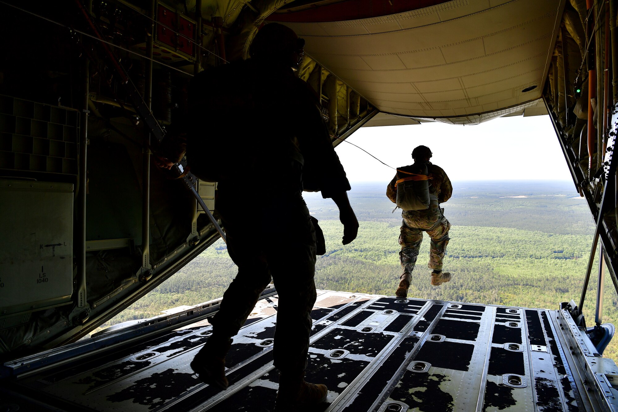 Master Sgt. Ed Dawejko and U.S. Air Force Tech. Sgt. Nader Maghribi, 19th Operations Support Squadron Survival Evasion Resistance and Escape specialists, perform a static-line jump over Sontay drop zone, Florida.