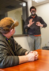 Facemasks, produced through efforts of the Sail Loft, Shop 64 and employees from the Home Team Mask project are distributed to Puget Sound Naval Shipyard & Intermediate Maintenance Facility deaf and hard of hearing employees. The mask were made with a see-through panel allowing employees to see lips and facial expressions. Trying one on for the first time is Brandon Salley, an electrical worker with Shop 51, Electricians.