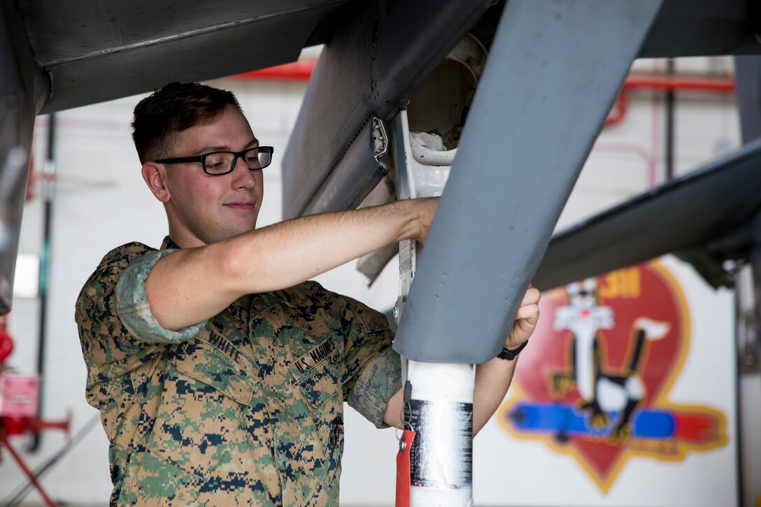 U.S. Marine Corps Sgt. Colan White, an airframe mechanic with Marine Attack Squadron 311, 3rd Marine Aircraft Wing, removes a landing gear down lock assembly from an AV-8B Harrier at Marine Corps Air Station (MCAS) Yuma, March 20, 2020. Marines continue to provide regularly scheduled maintenance on the aircraft aboard MCAS Yuma while practicing social distancing and maintaining a clean working environment.(U.S. Marine Corps photo by Cpl. Nicole Rogge)