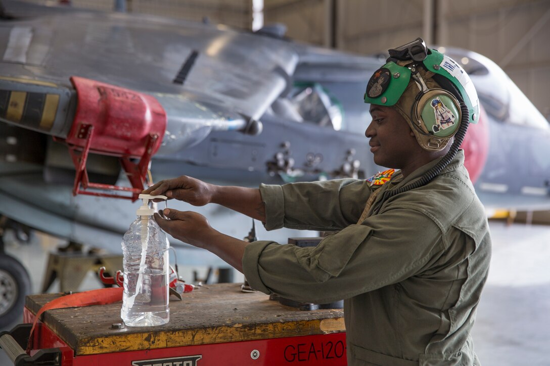 U.S. Marine Corps Cpl. Timothy Duran, an airframe mechanic with Marine Attack Squadron 311, 3rd Marine Aircraft Wing, applies hand sanitizer after assisting with the maintenance of an AV-8B Harrier at Marine Corps Air Station (MCAS) Yuma, March 20, 2020. Marines continue to provide regularly scheduled maintenance on the aircraft aboard MCAS Yuma while practicing social distancing and maintaining a clean working environment. (U.S. Marine Corps photo by Cpl. Nicole Rogge)