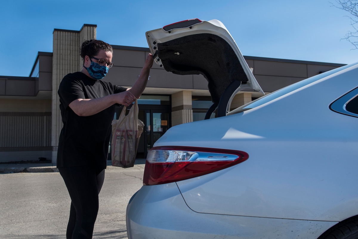 Dannon Jiskra, an Eielson commissary employee, places groceries into a vehicle at Eielson Air Force Base, Alaska, April 30, 2020. The commissary launched the curbside pick-up program to help minimize social contact while shopping. (U.S. Air Force photo by Airman 1st Class Aaron Larue Guerrisky)