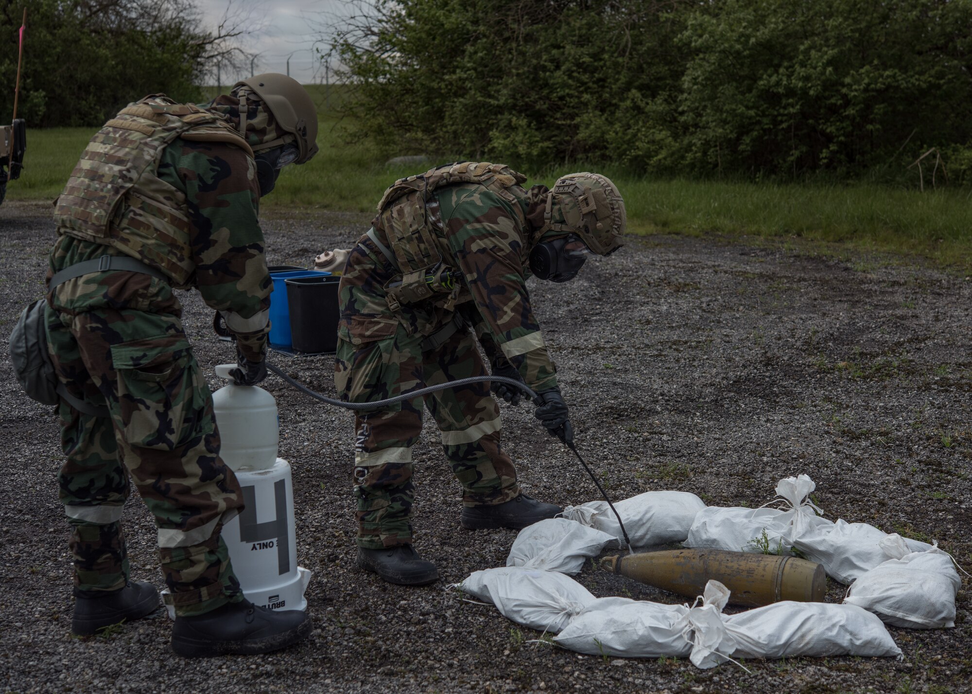 Senior Airman Dawson Hindman, left, and Airman 1st Class Christopher Jordan, both 509th Civil Engineer Squadron Explosive Ordnance Disposal technicians, clean a simulated chemical ordnance during training at Whiteman Air Force Base, Missouri, April 30, 2020.