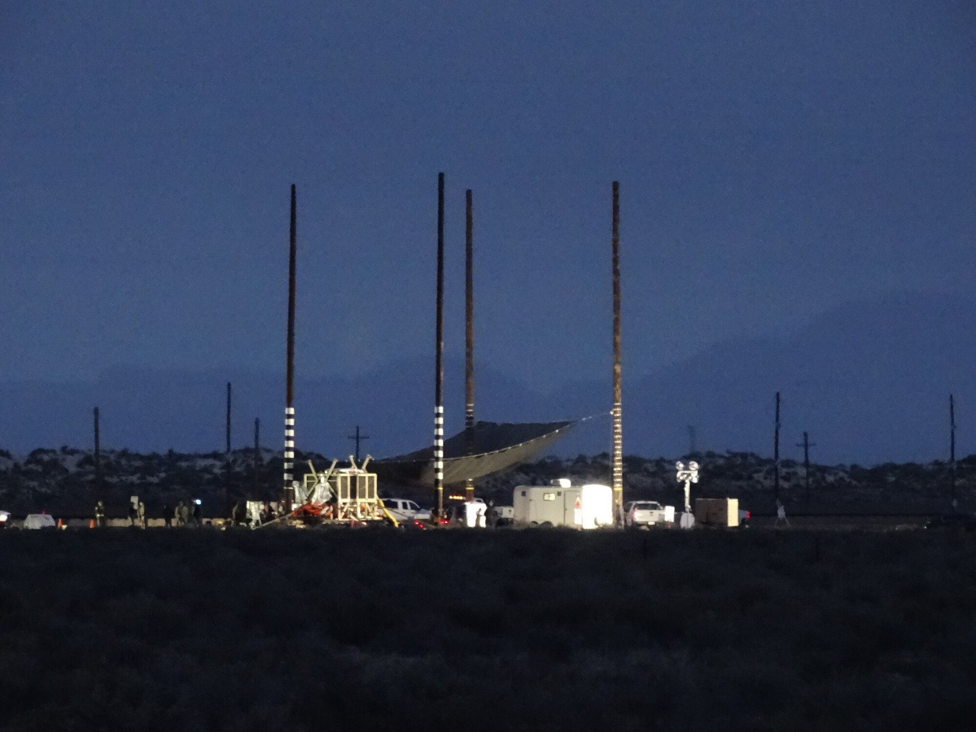 The test site shown from a distance the morning of a static F-35 canopy test March 27, 2020, at Holloman Air Force Base, N.M. The unique test, performed by the 846th Test Squadron, 704th Test Group, Arnold Engineering Development Complex, required the canopy to be heat soaked to a very high, specific temperature range while controlling the internal temperature of the ejection seat and manikin within their much lower, temperature range. Additionally, large poles support a soft catch net to safely recover the ejection seat and manikin post-test with minimal damage to the test items. (U.S. Air Force photo by Timothy Gros)