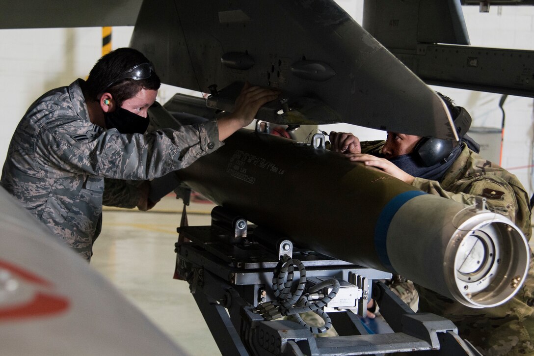 Airman 1st Class Alexis Lugo, left, weapons load crew member and Staff Sgt. Gabriel Bongat, weapons load crew chief, both with the 314 Aircraft Maintenance Unit, inspect a munition during the first quarter load competition April 28, 2020, at Holloman Air Force Base, N.M. This timed event held, quarterly, aids in enhancing Airmen’s technical abilities to load munitions onto aircrafts with precision and speed.   (U.S. Air Force photo by Senior Airman Collette Brooks)