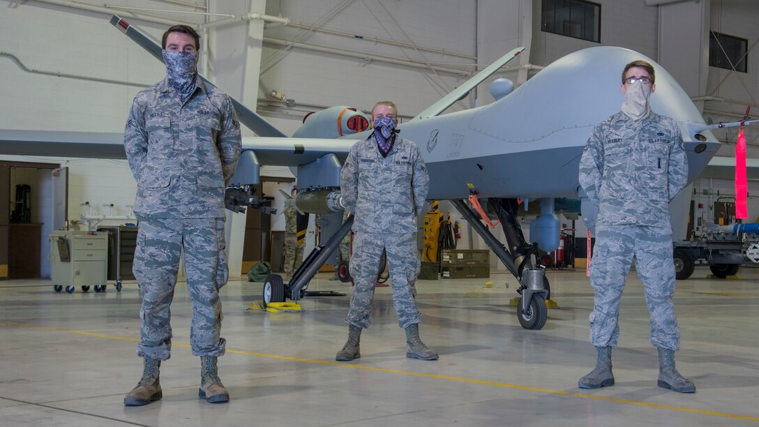 Airman 1st Class Dalton Hottle, right, and Airman 1st Class Richard Robertson, center; both 9th Aircraft Maintenance Unit weapon load crew members, and Staff Sgt. Jonathan Bradley, 9th AMU weapons load crew chief, pose for a photo in front of a MQ-9 Reaper during the first quarter load competition April 28, 2020, at Holloman Air Force Base, N.M. Team Holloman Airmen from various AMUs compete quarterly on their ability to quickly and properly arm their respective aircrafts with munitions in order to enhance their weapons loading technical skills and capabilities. (U.S. Air Force photo by Senior Airman Collette Brooks)