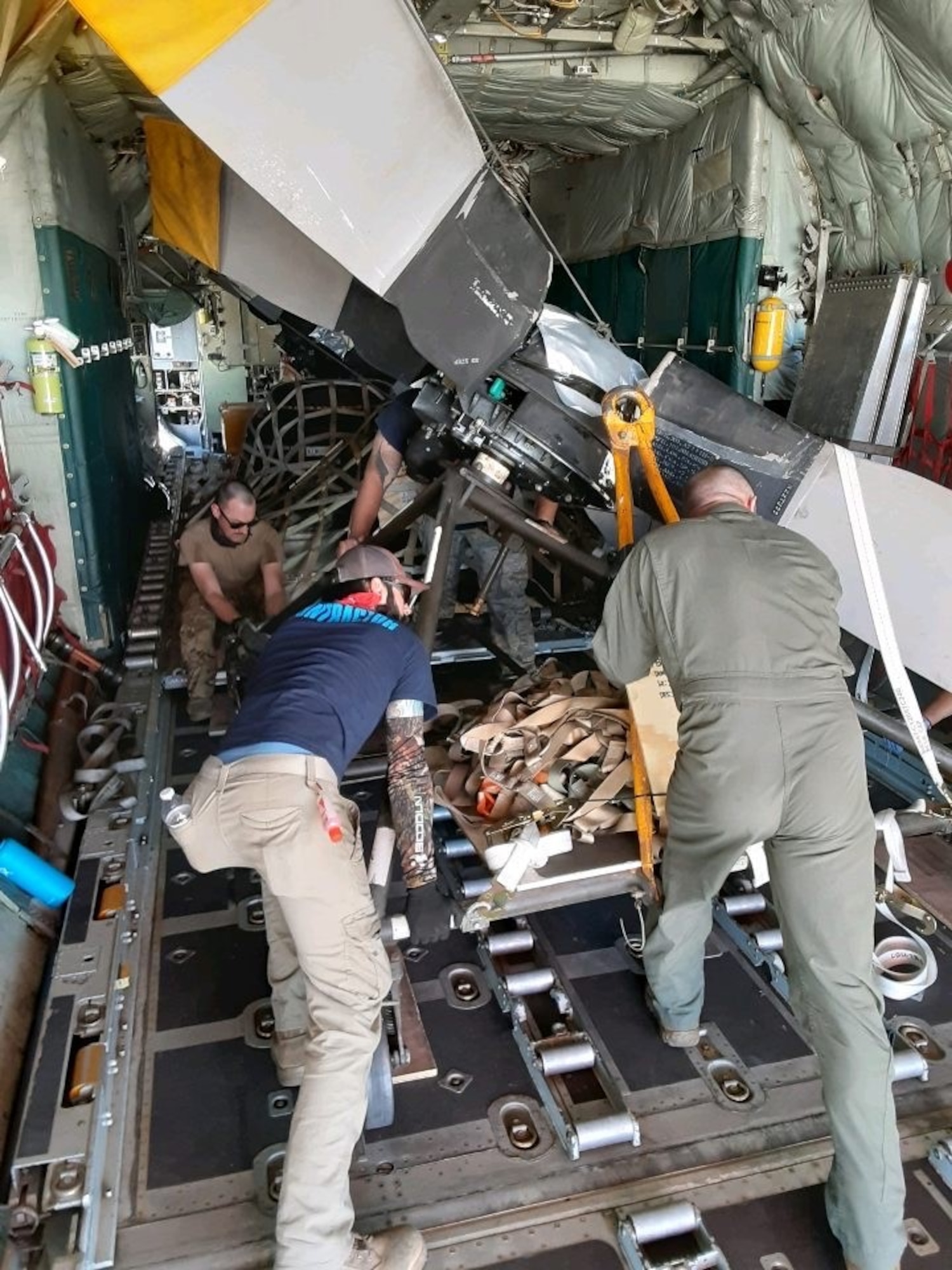 514th Flight Test Squadron aircrew and 309th Aerospace Maintenance and Regeneration Group personnel pushing a propeller in the back of an aircraft.
