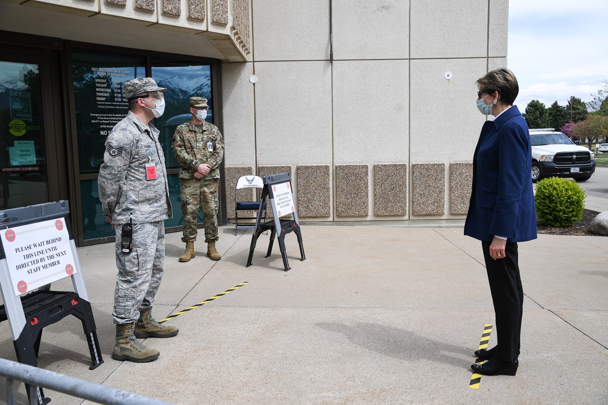 Secretary of the Air Force Barbara Barrett is screened by Staff Sgt. Ryan Thomas, 75th Medical Group, near the front doors of the medical clinic.