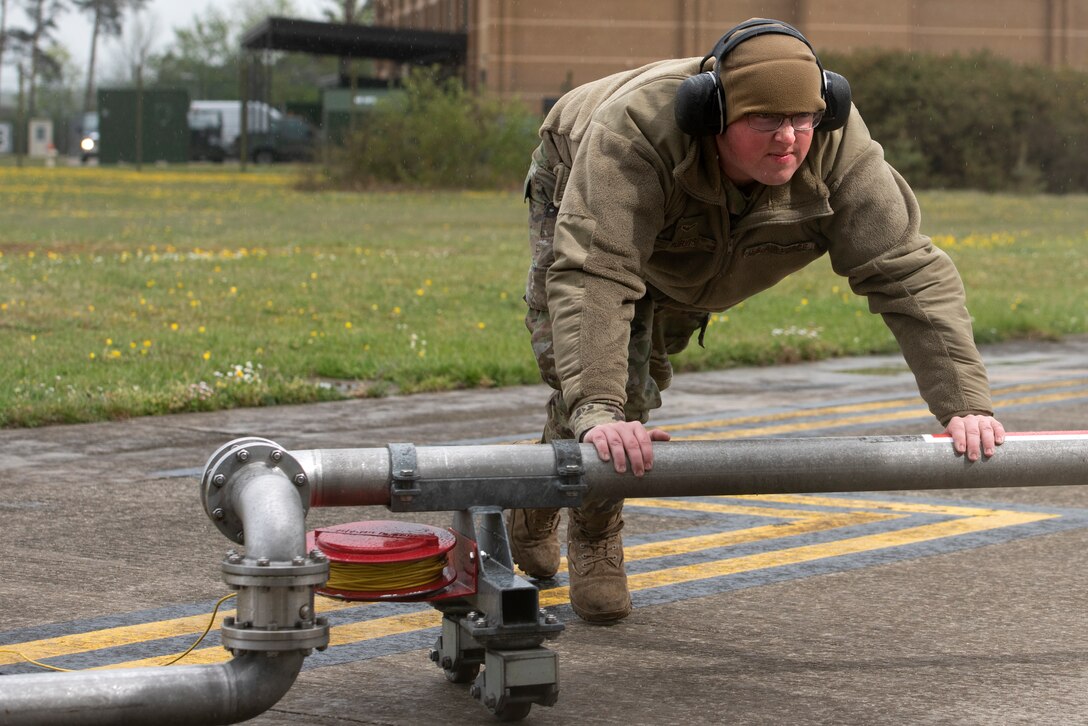 Airman 1st Class Corey Purvis, a 48th Logistics Readiness Squadron fuels mobile distribution operator, pushes the mobile pantograph out to an F-15C Eagle for "hot pit" refueling operations at Royal Air Force Lakenheath, England, April 30, 2020. Continued “hot pits” during the COVID-19 pandemic provide necessary training and experience required to reduce the ground time between sorties by refueling active aircraft, enabling maximum training in a shorter time frame. (U.S. Air Force photo by Airman 1st Class Jessi Monte)