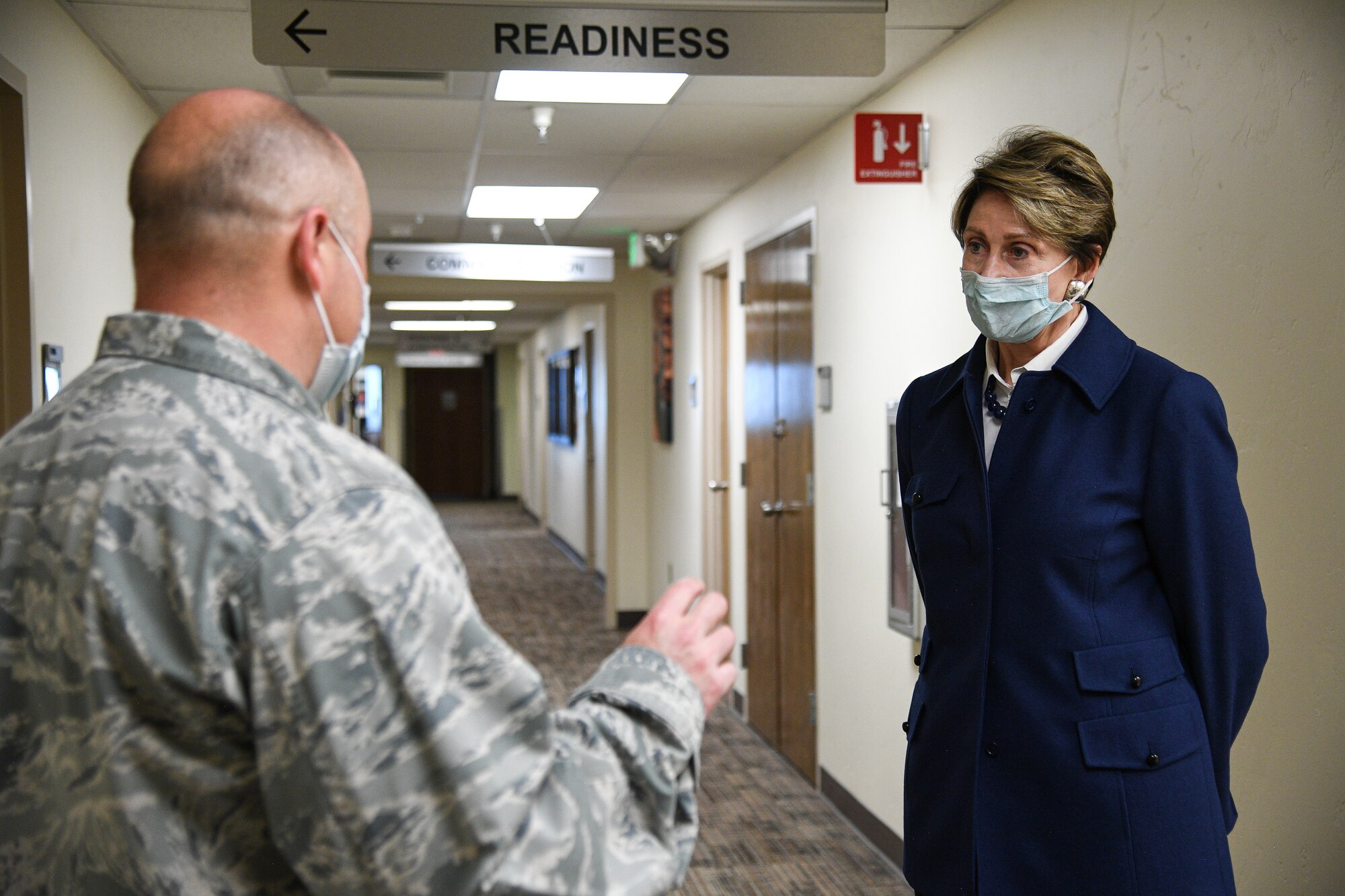 cretary of the Air Force Barbara Barrett listens to Lt. Col. Gabriel Pepper, 75th Medical Group,in a hallway at the medical clinic.