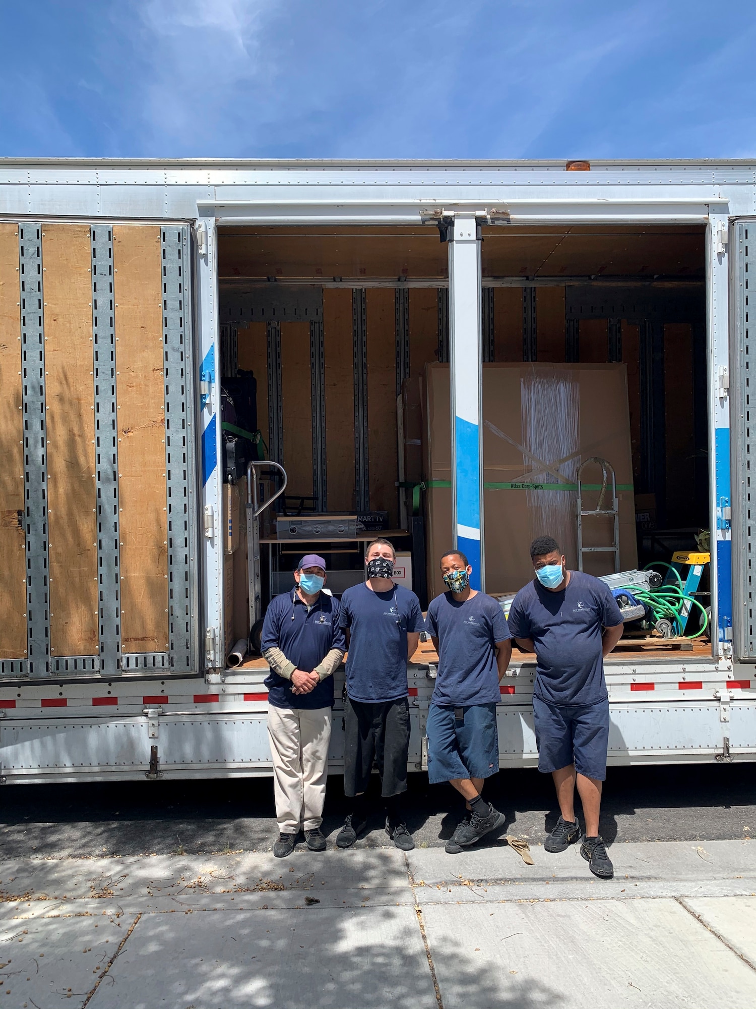 Movers stand together outside the home of Capt. Anthony, after loading up his home goods at Las Vegas, Nevada, April 28, 2020.