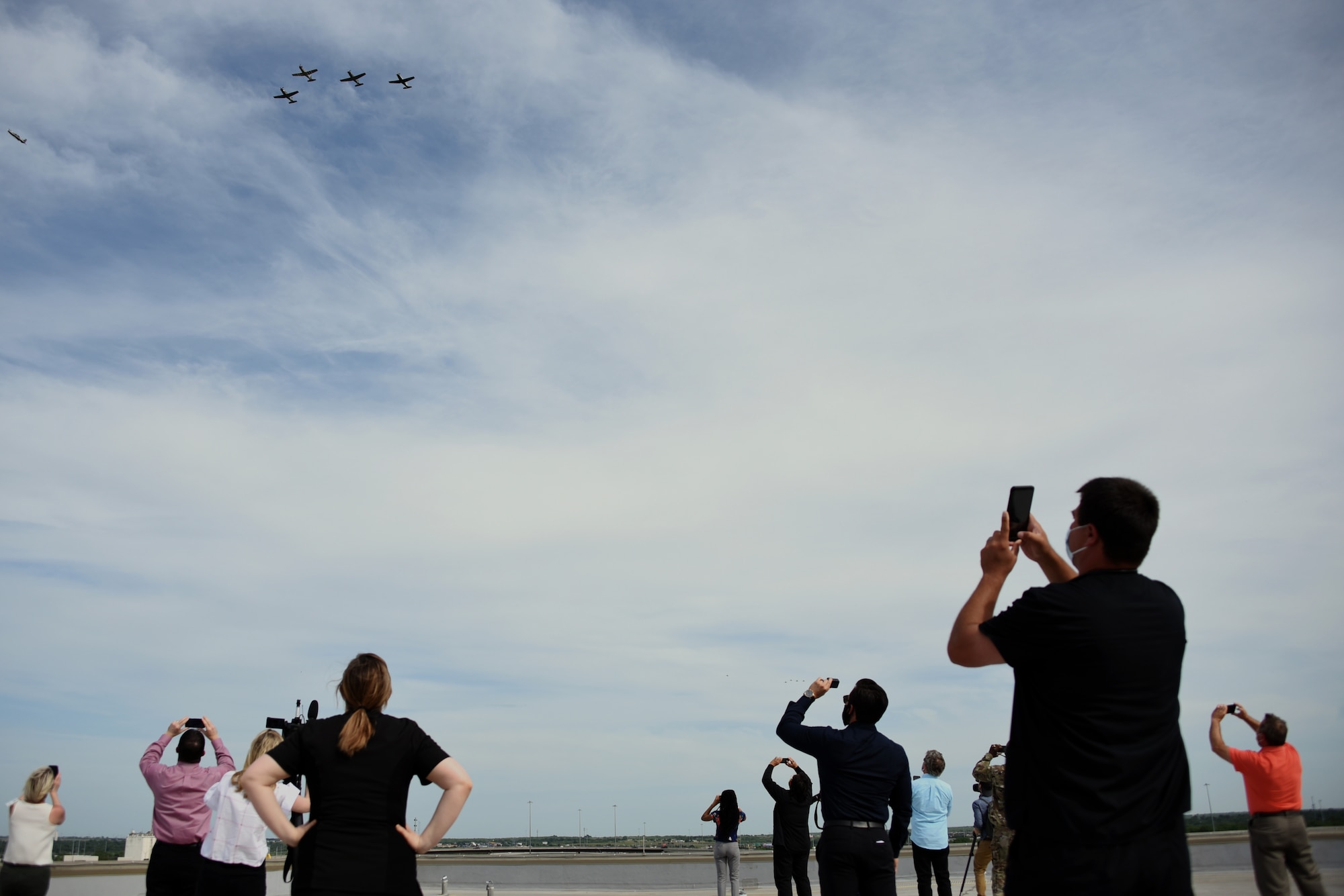 Members of the United Regional Hospital in Wichita Falls, Texas, observe the Spirit of Texoma flyover, May 1, 2020. The flyover was a way for Sheppard Air Force Base, Texas, to show gratitude towards the COVID-19 frontline healthcare workers in the local community. The flyover consisted of a 4-ship T-38 Talon formation and a 4-ship T-6 Texan II formation, with a T-38 and T-6 chase plane behind them for photo and video. (U. S. Air Force photo by Staff Sgt. Robert L. McIlrath)