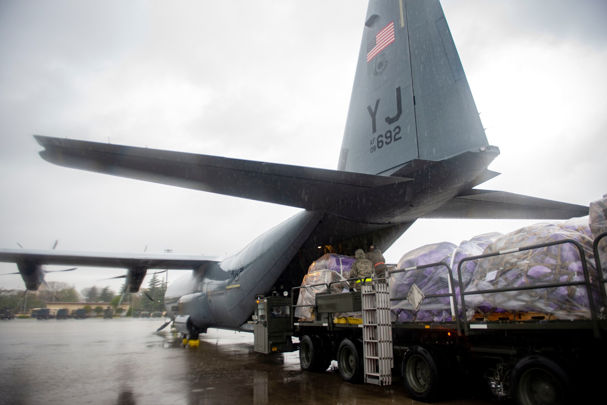 Airmen with 730th Air Mobility Squadron load pallets of mail on a C-130J Super Hercules, assigned to the 36th Airlift Squadron, on the flight line at Yokota Air Base, Japan, April 18, 2020. Due to COVID-19, planes that would normally take the mail, bound for Misawa Air Base, Japan, from Haneda or Narita Airport, have been reduced to one flight per day, requiring the mail to be processed and flown through Yokota. (U.S. Air Force photo by Senior Airman Gabrielle Spalding)