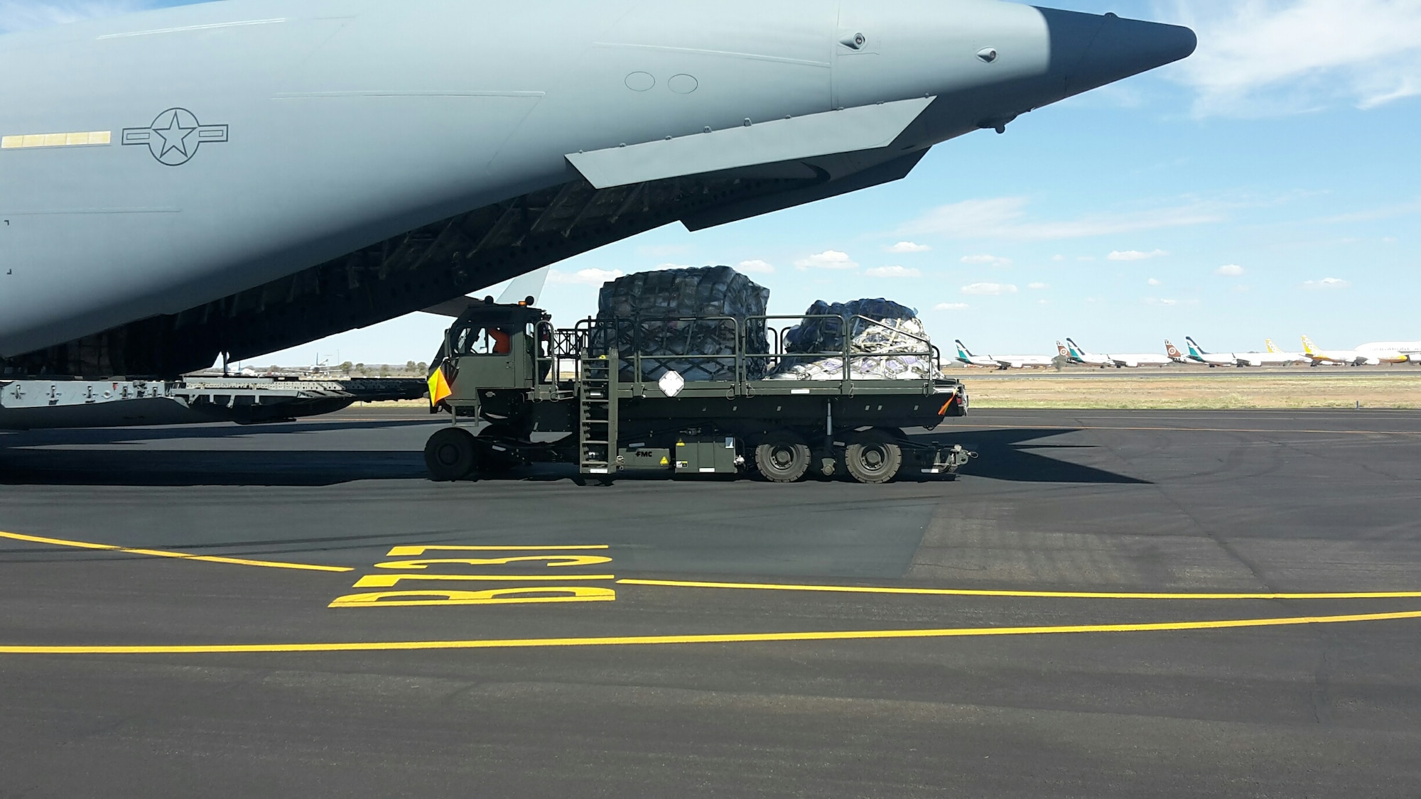 Palletized mail is unloaded off of a C-17 Globemaster III at Alice Springs, Australia, April 28, 2020. The Pacific Air Forces Air Postal Squadron partnered with the U.S. Army, U.S. Air Force Air Mobility Command as well as the U.S. Navy to deliver thousands of pounds of mail to Republic of Korea, Japan, and Australia. (Courtesy Photo)