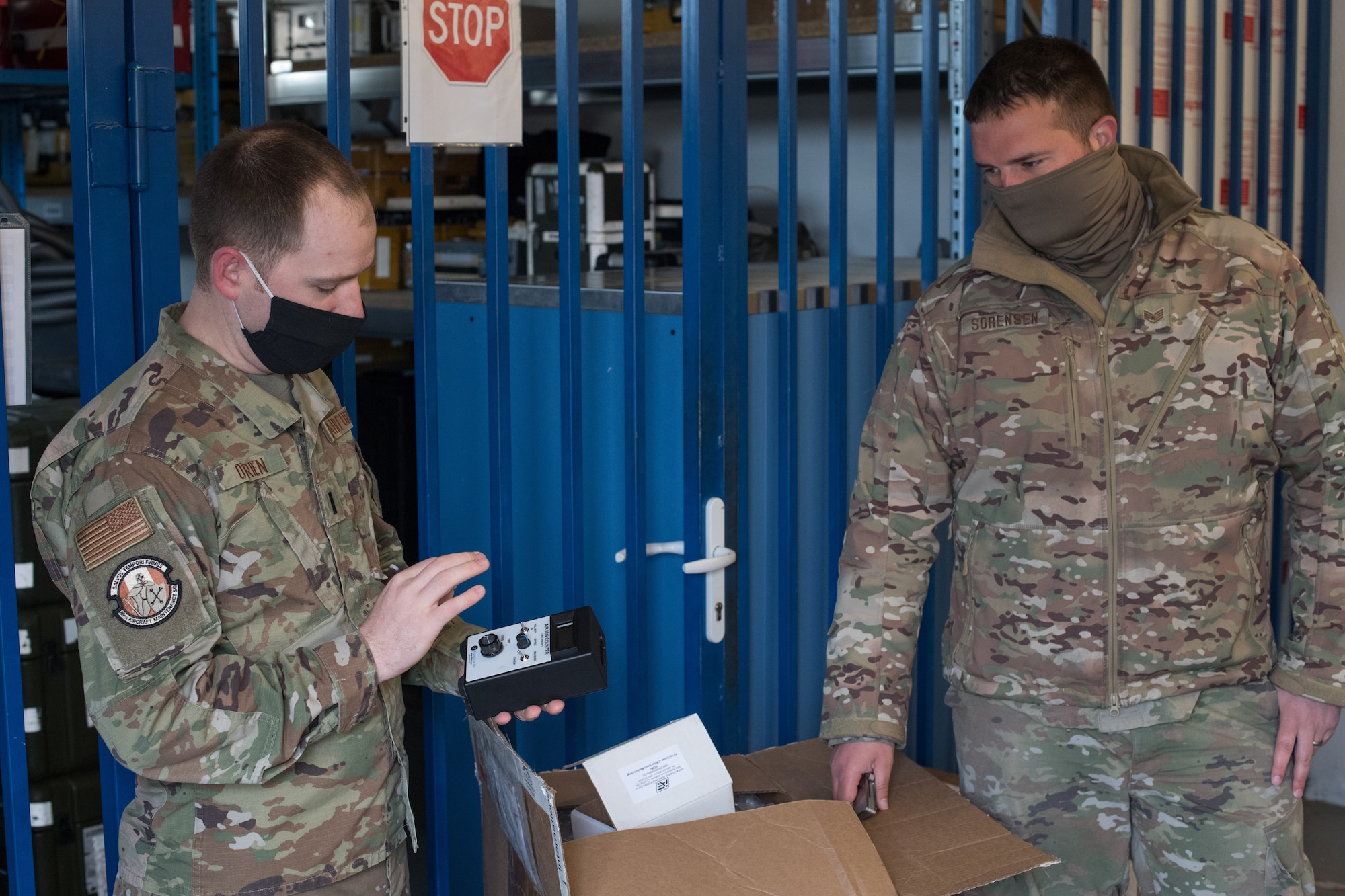 Two Airmen looking at an ion counting device.
