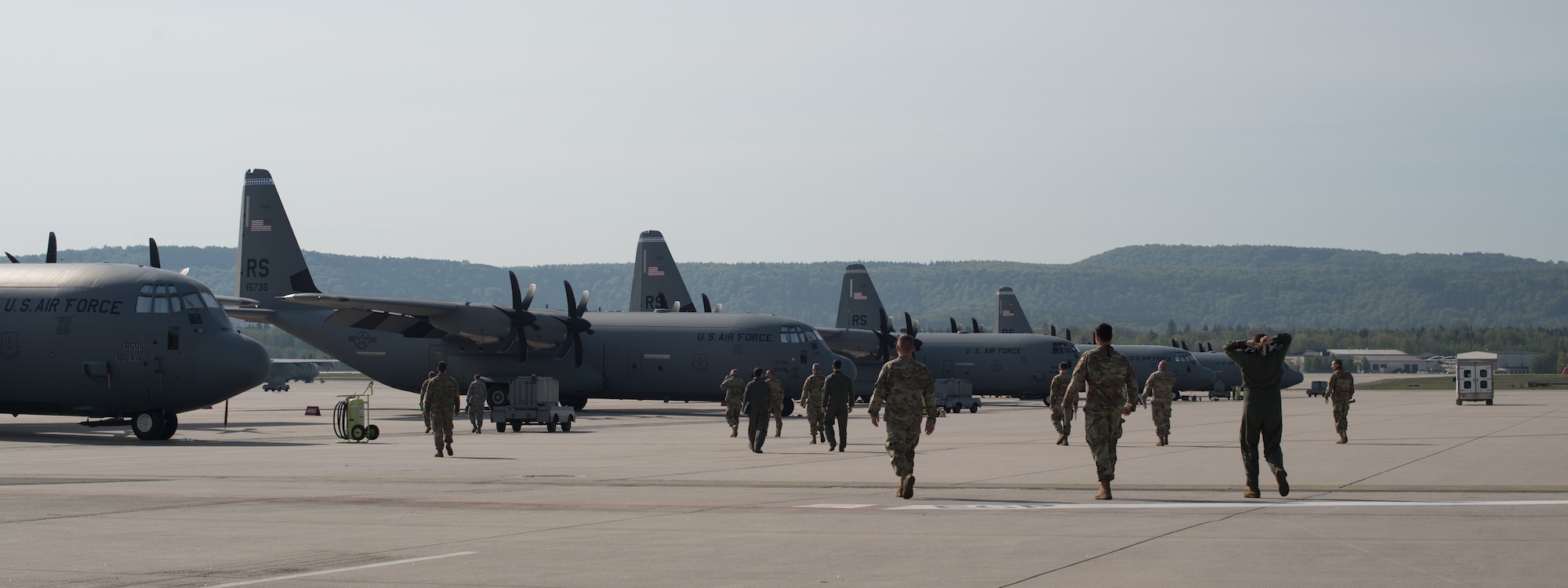 A group of Airmen walk toward a fleet of aircraft.
