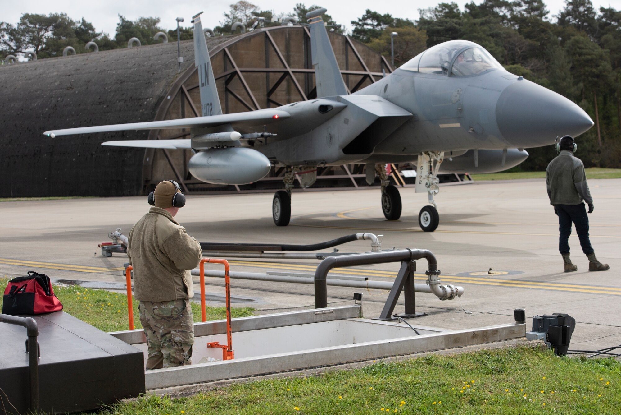 48th Fighter Wing Airmen prepare to perform "hot pit" refueling operations on an F-15C Eagle at Royal Air Force Lakenheath, England, April 30, 2020. Continued “hot pits” during the COVID-19 pandemic provide necessary training and experience required to reduce the ground time between sorties by refueling active aircraft, enabling maximum training in a shorter time frame. (U.S. Air Force photo by Airman 1st Class Jessi Monte)