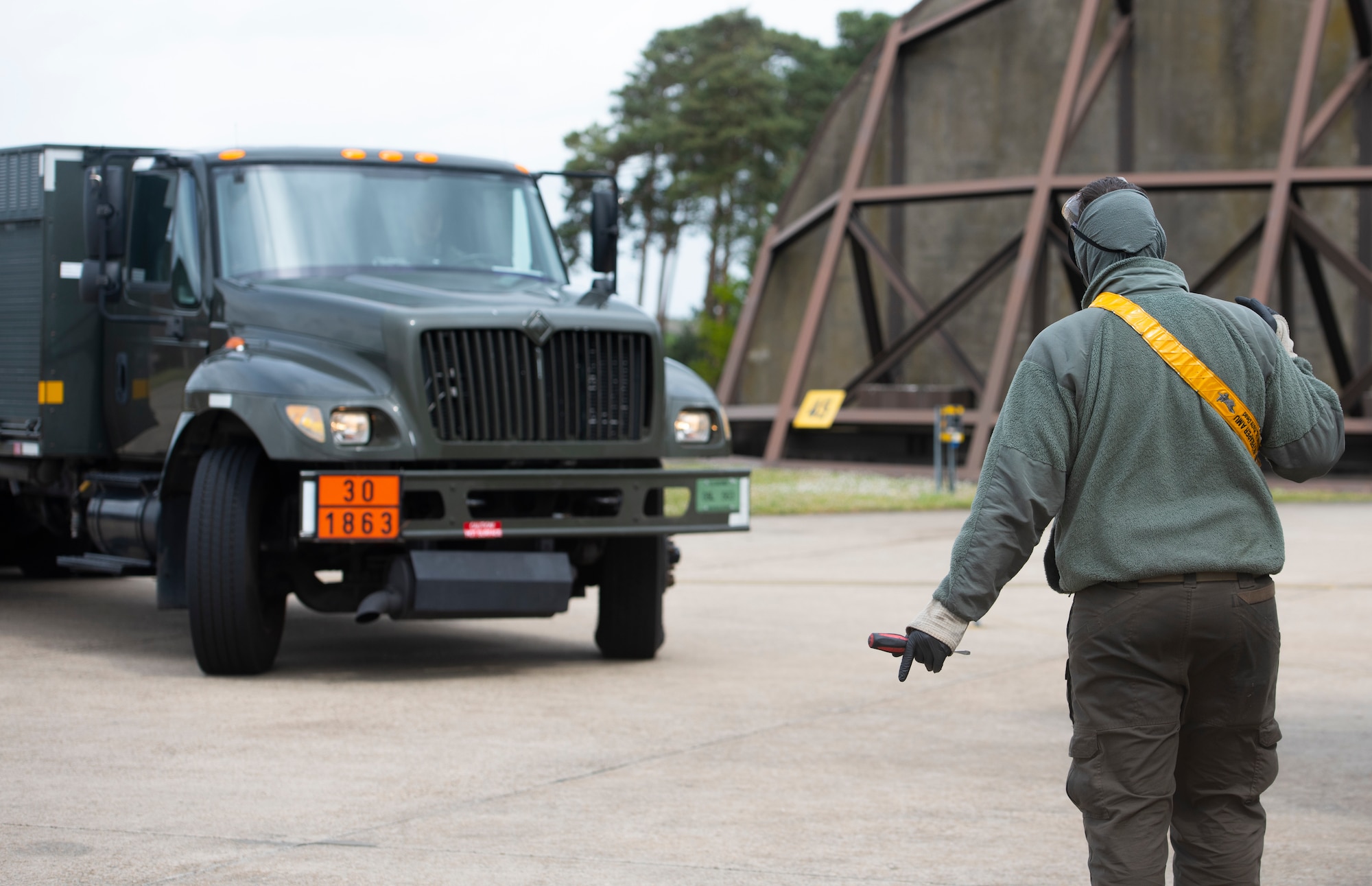 A crew chief assigned to the 493rd Aircraft Maintenance Unit directs an R-11 refueling truck at Royal Air Force Lakenheath, England, April 30, 2020. 48th Logistics Readiness Squadron Airmen work closely with crew chiefs to deliver over 350,000 gallons of JP-8 fuel per week, despite the current COVID-19 pandemic. (U.S. Air Force photo by Airman 1st Class Jessi Monte)