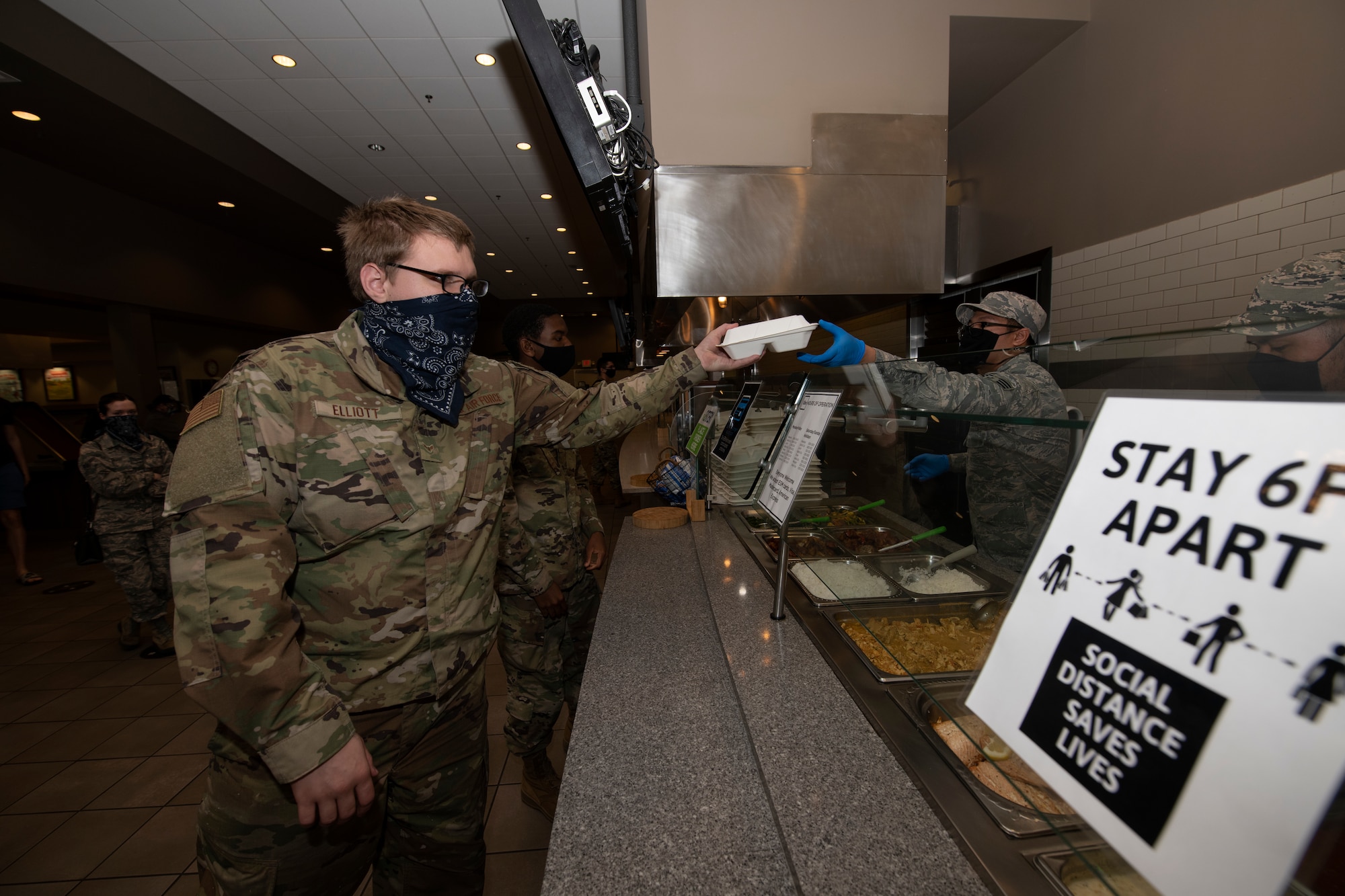 U.S. Air Force Airman 1st Class Derek Elliot, 60th Logistics Readiness Squadron material management specialist, grabs his lunch inside the Monarch Dining Facility April 24, 2020, at Travis Air Force Base, California. The Monarch is offering to-go meals to service members only due to the coronavirus pandemic. (U.S. Air Force photo by Tech. Sgt. James Hodgman)